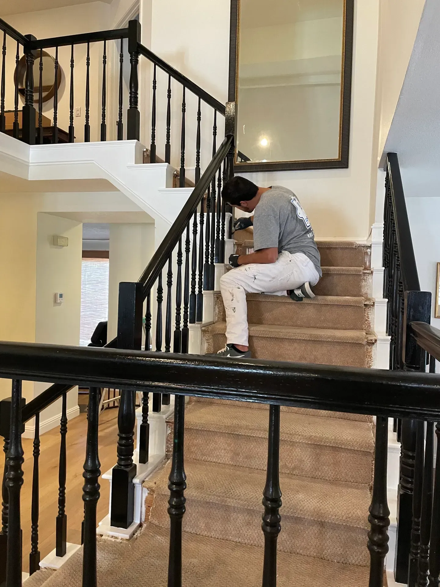 A man is sitting on a set of stairs in a house.
