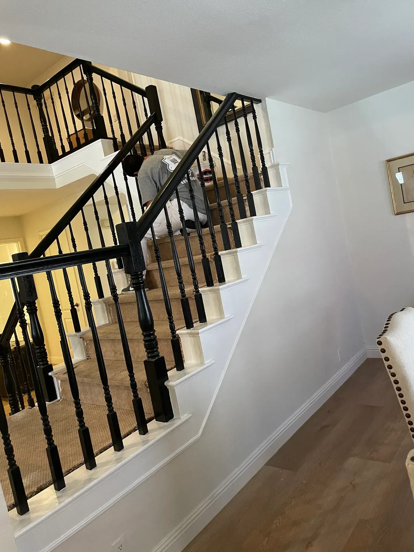 A man is standing on a set of stairs in a house.