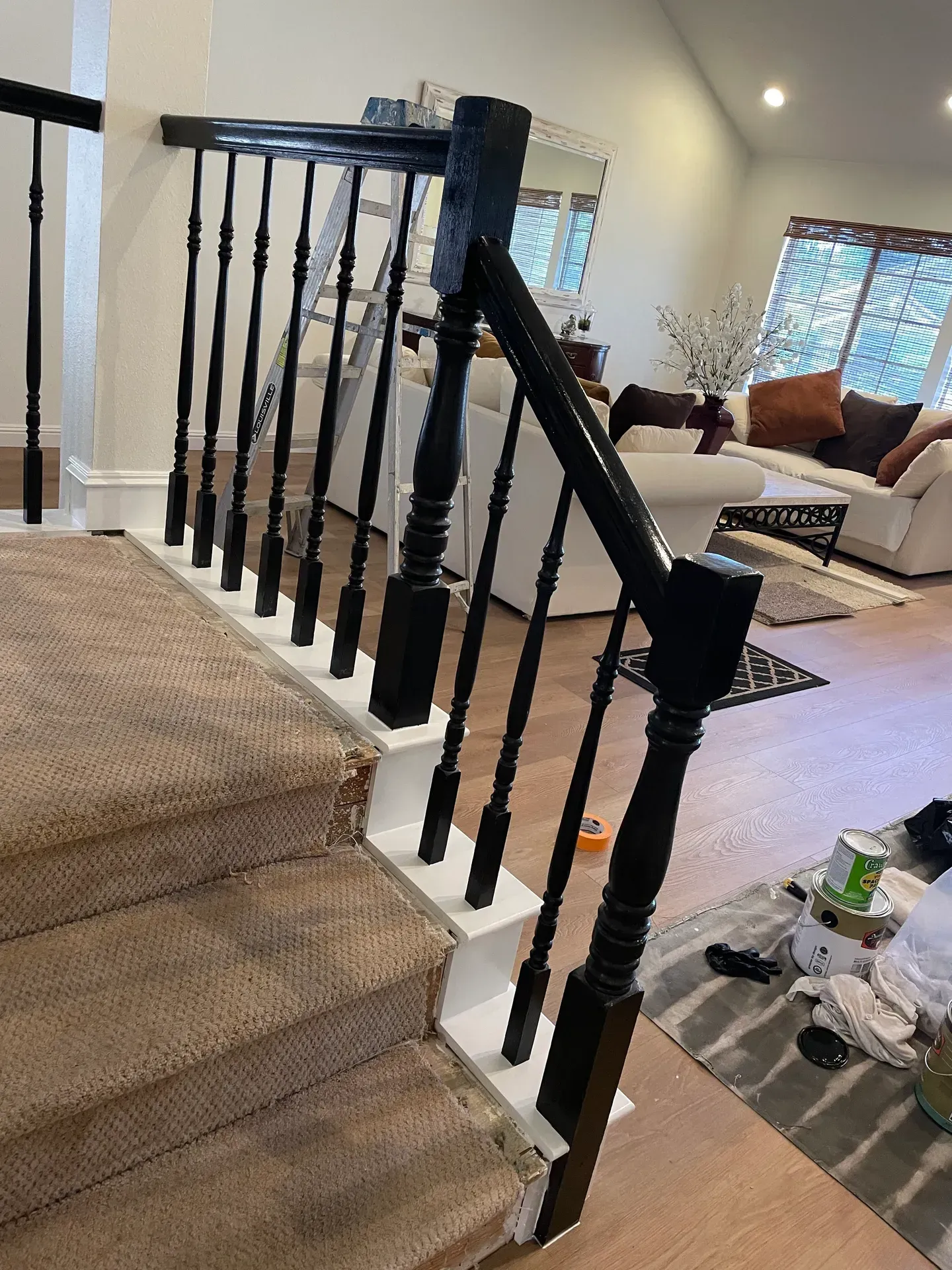 A black railing on a set of stairs in a living room.