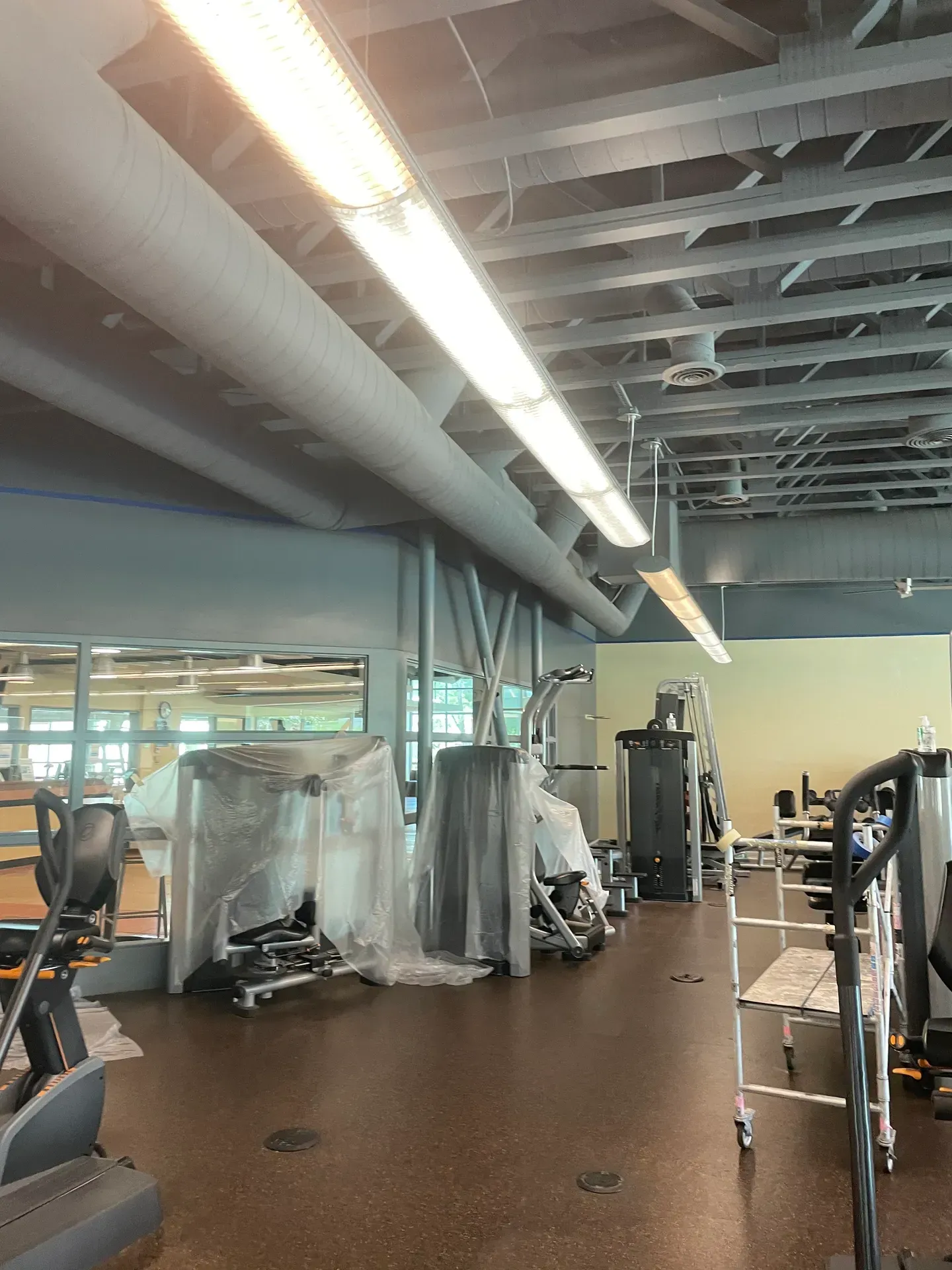 A gym with a lot of equipment including a treadmill