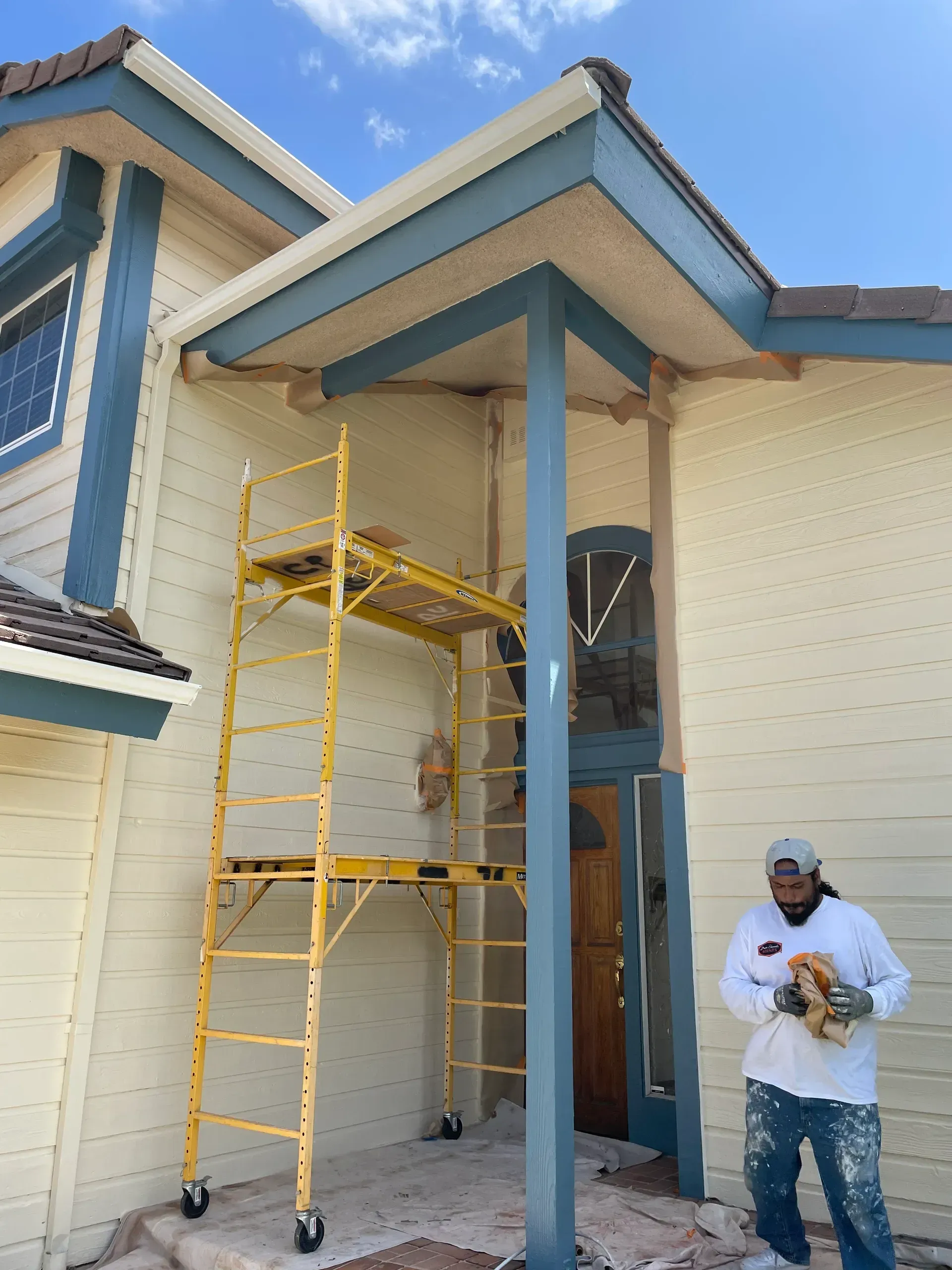A man is painting a wall in an empty room.