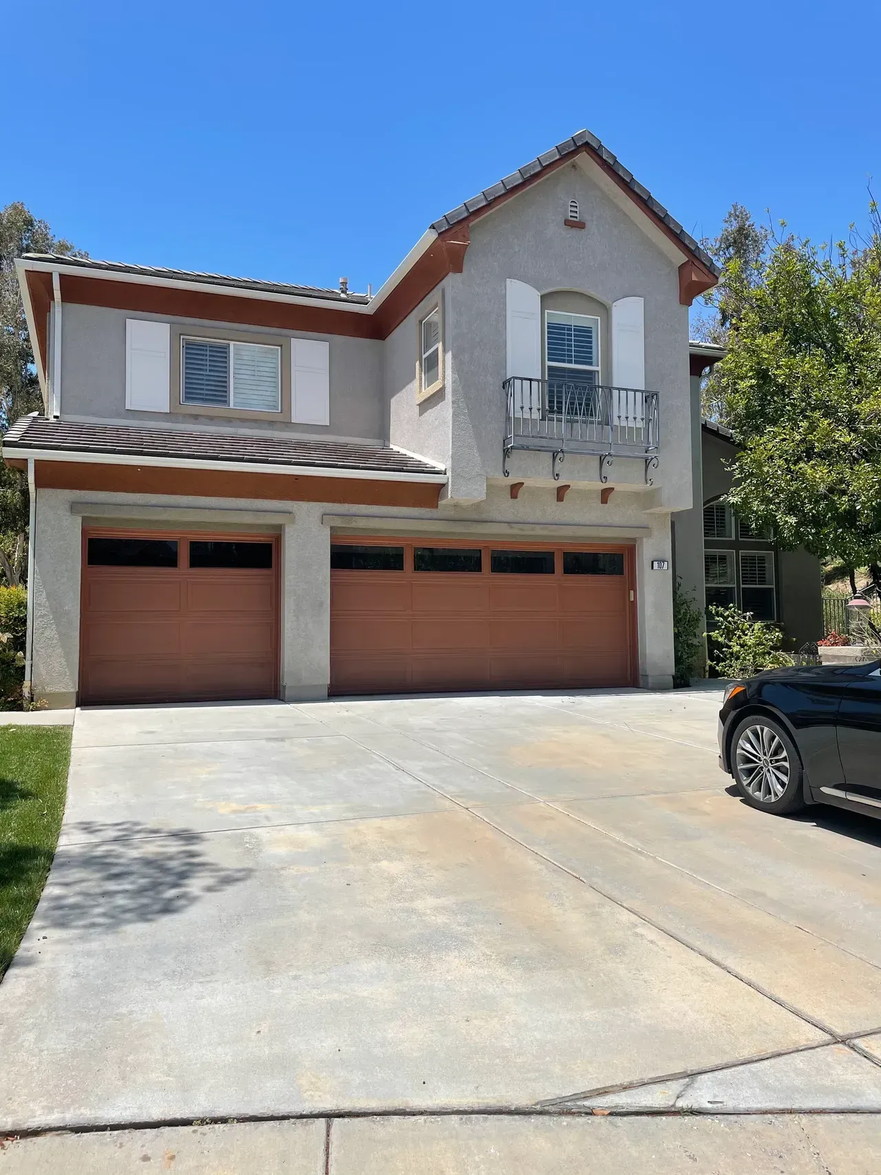 A car is parked in front of a large house