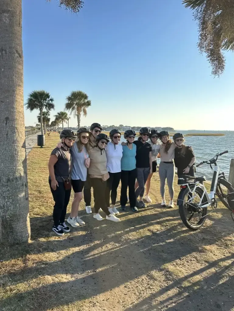 A group of people are posing for a picture next to a bicycle.