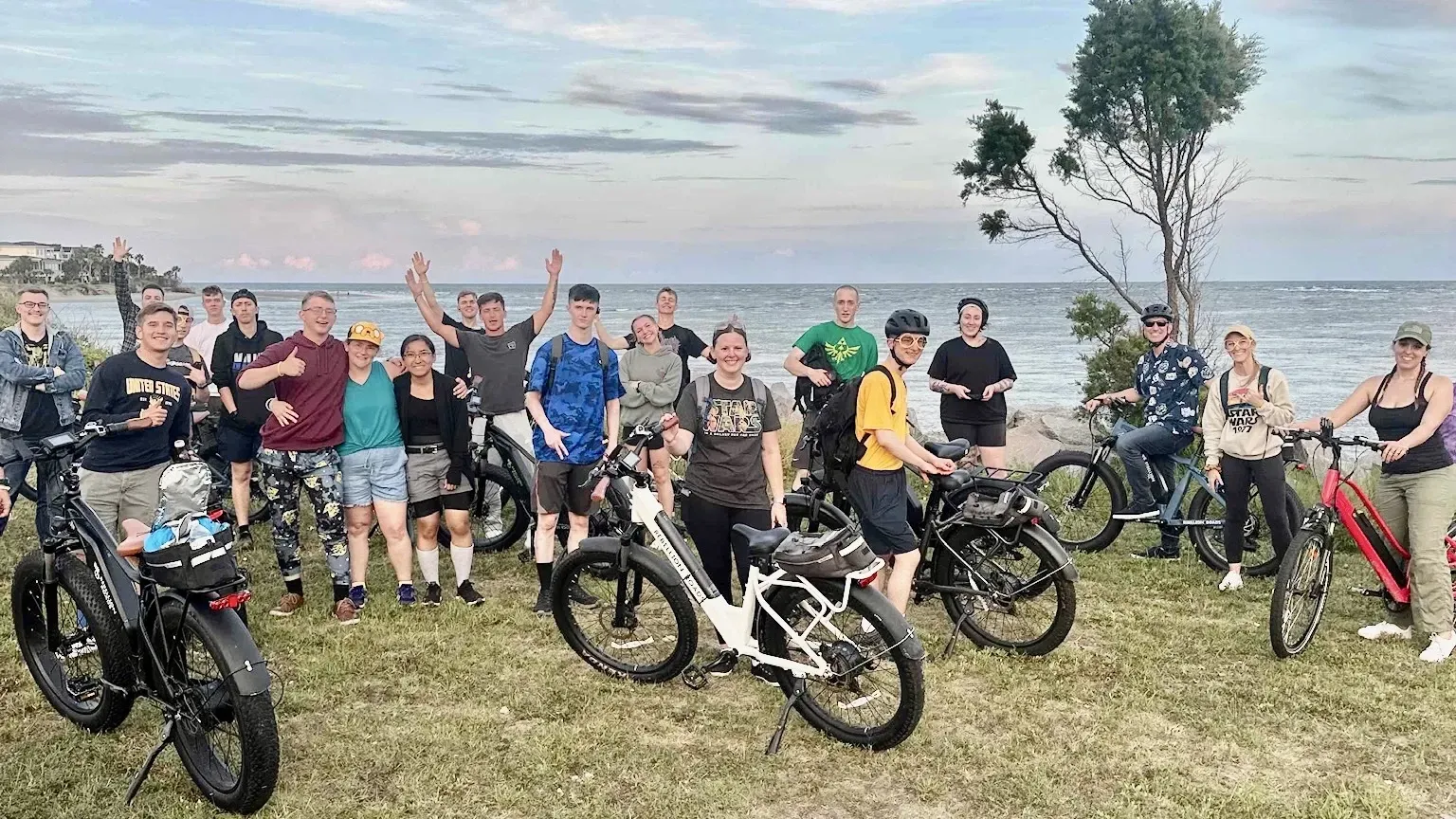 A group of people are standing next to each other on bicycles in a field.