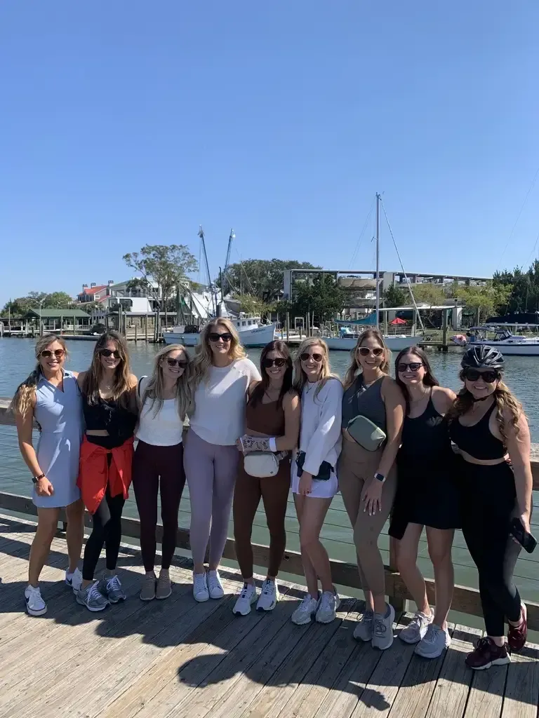 A group of women are posing for a picture on a pier on a Shores Tour from Rebellion Roads