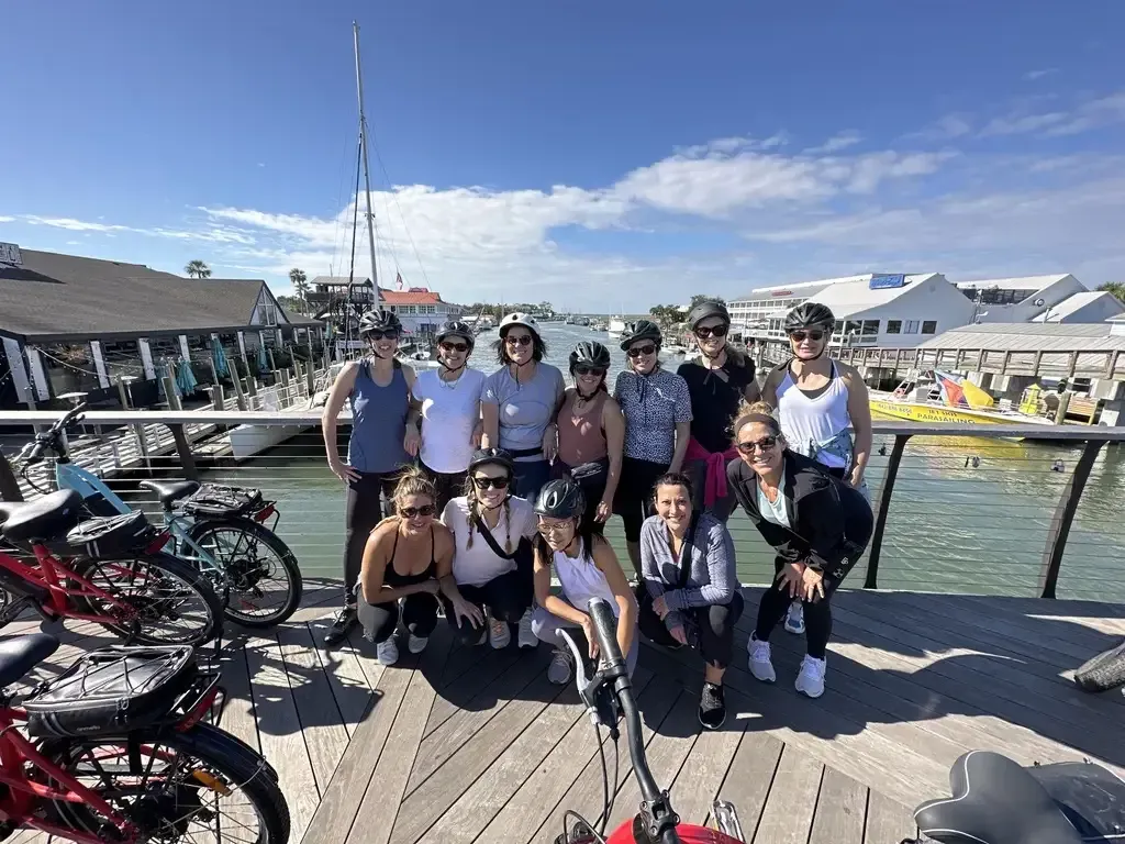 A group of people are posing for a picture on a dock on the Shores Tour