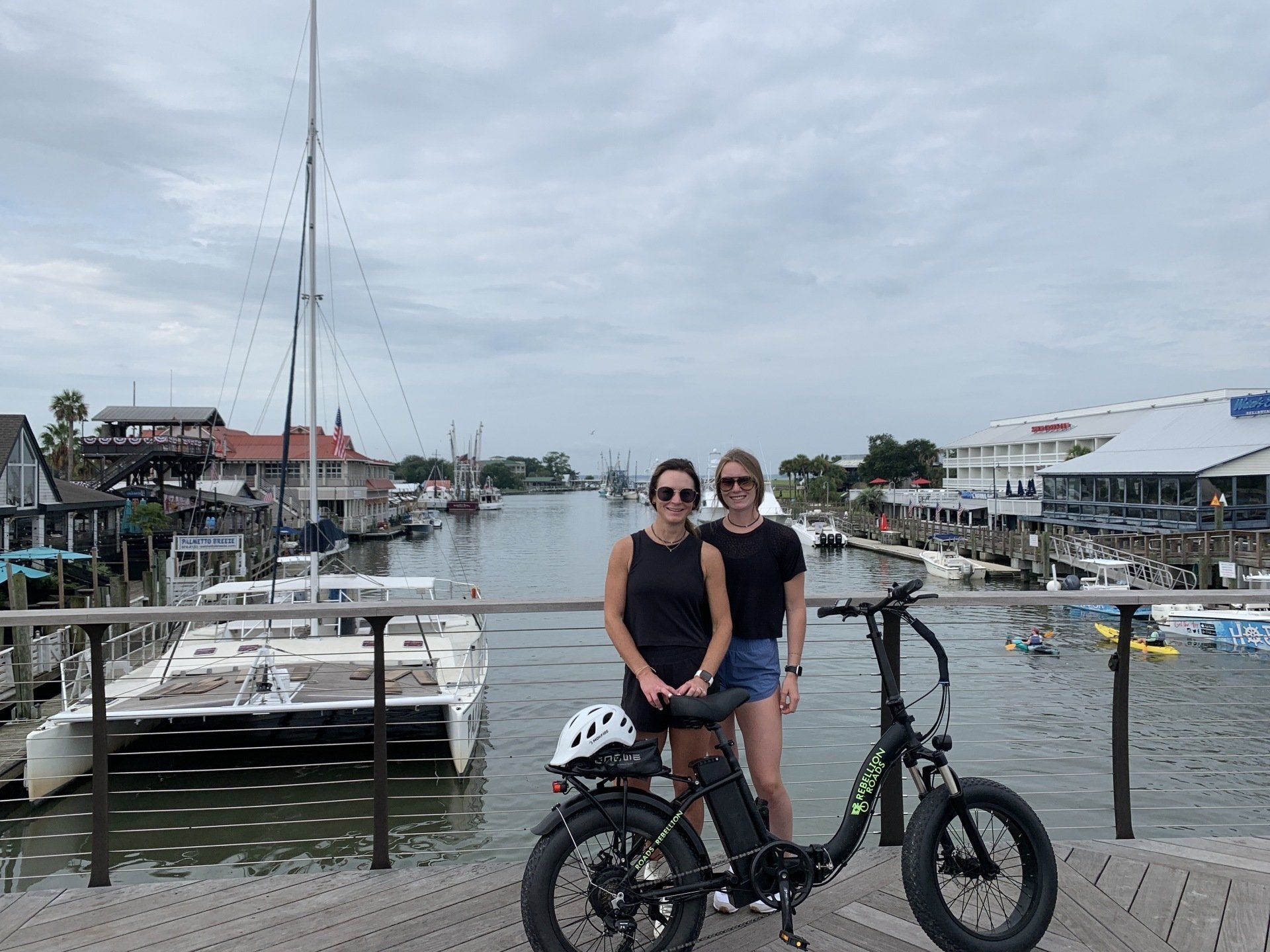 Two woman smiling and their bike on the front