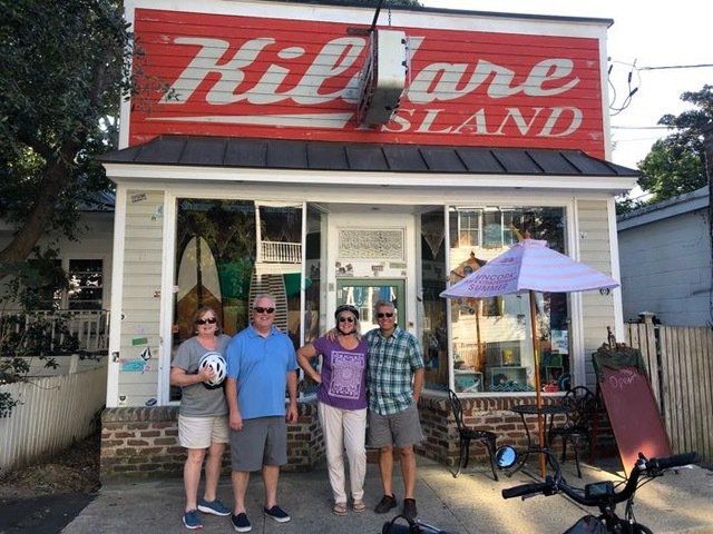 a group of people standing in front of a store called kilgore island