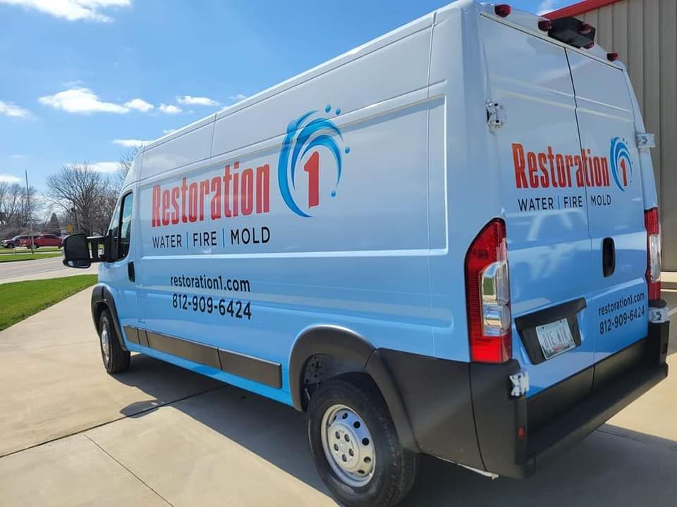 A restoration 1 van is parked on the side of the road.