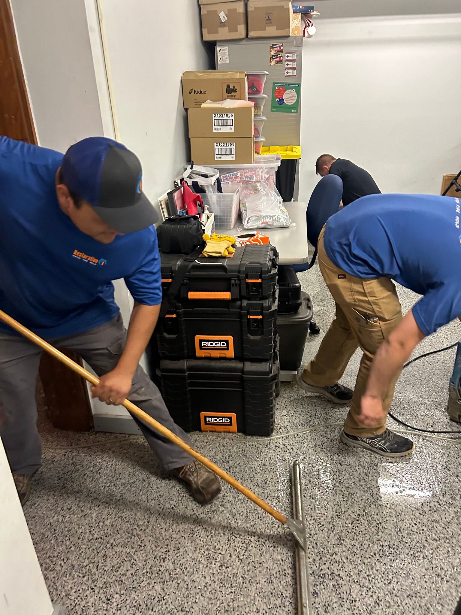 A group of men are working on a floor in a room.