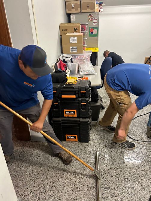 A group of men are working on a floor in a room.