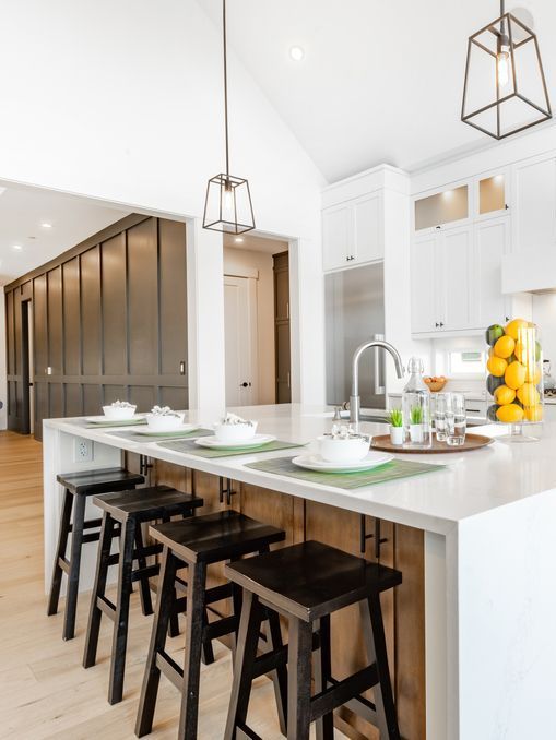 A kitchen with a long island and stools.