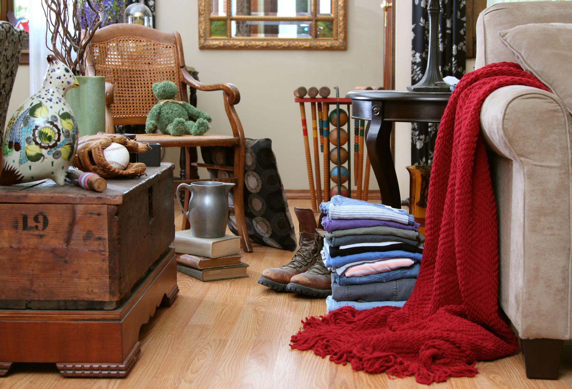 A living room with a stack of clothes on the floor