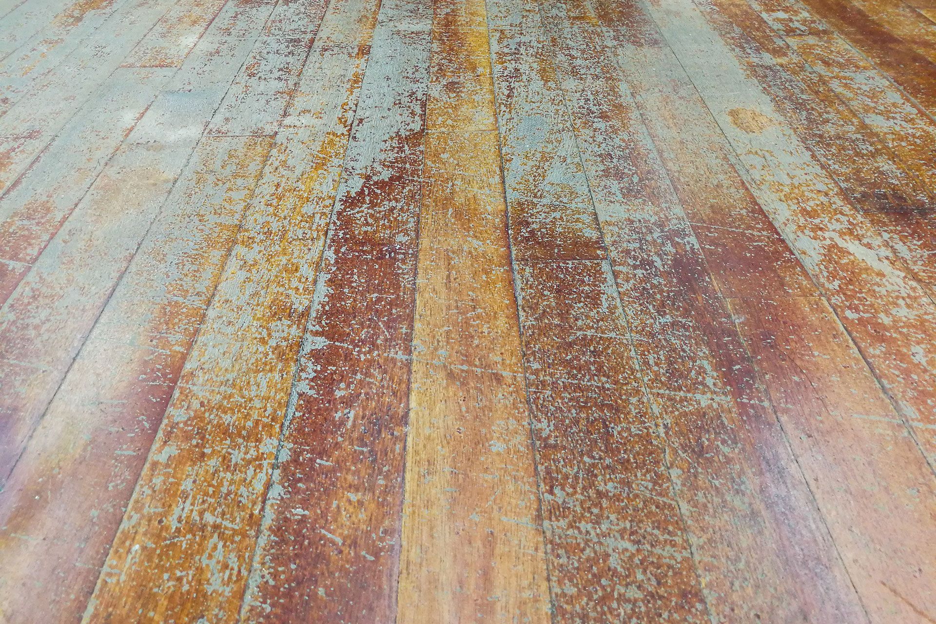 A close up of a wooden floor with a lot of stains on it.