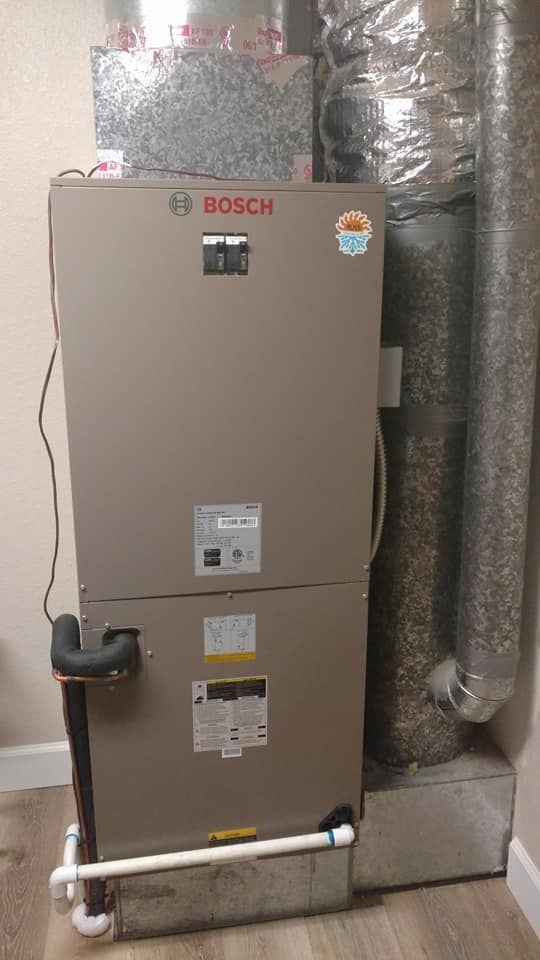 A bosch air conditioner is sitting in a basement next to a wall.