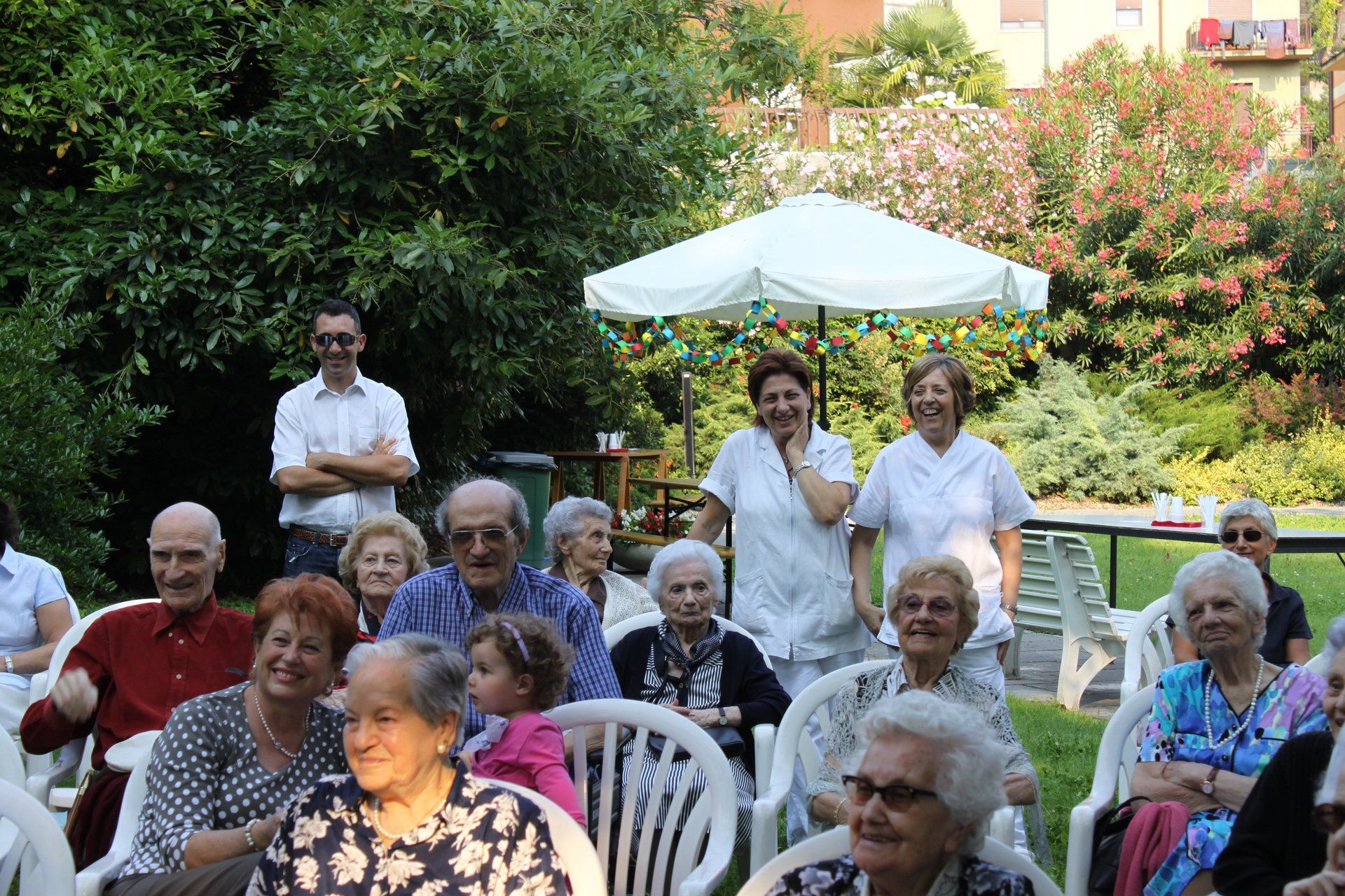persone anziane con infermieri in un giardino