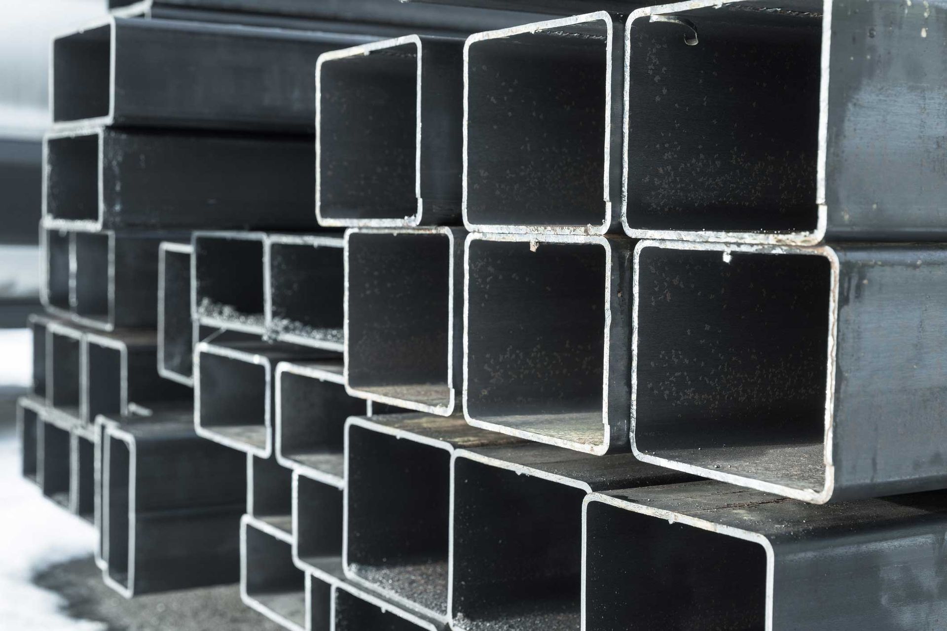 A stack of square metal pipes sitting on top of each other