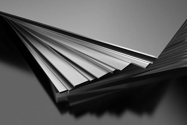 A close up of a stack of metal sheets on a black surface