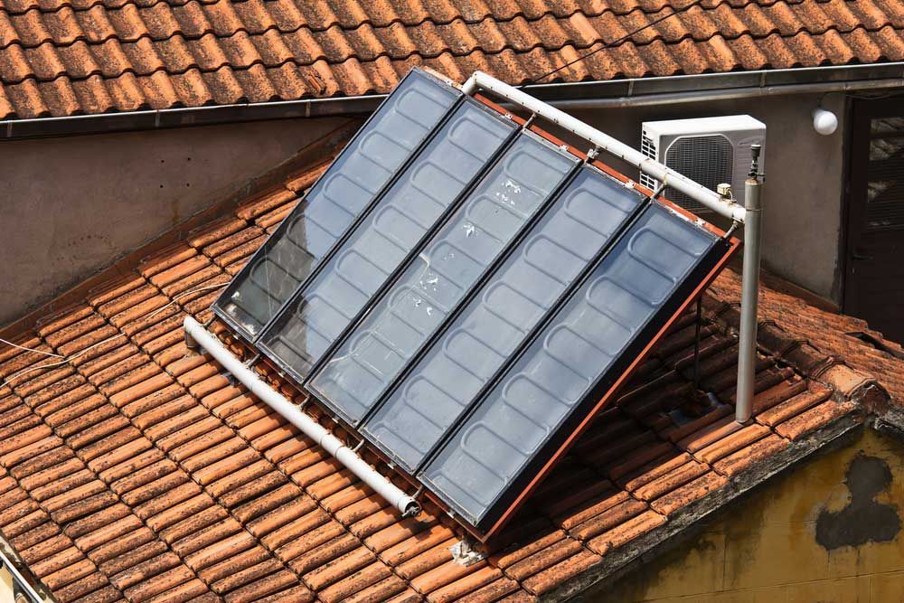 Solar water heating system on a tiled roof — Plumbers in Illawarra, NSW