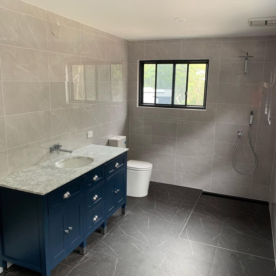 Sink with toilet and grey tiles — Plumbers in Illawarra, NSW