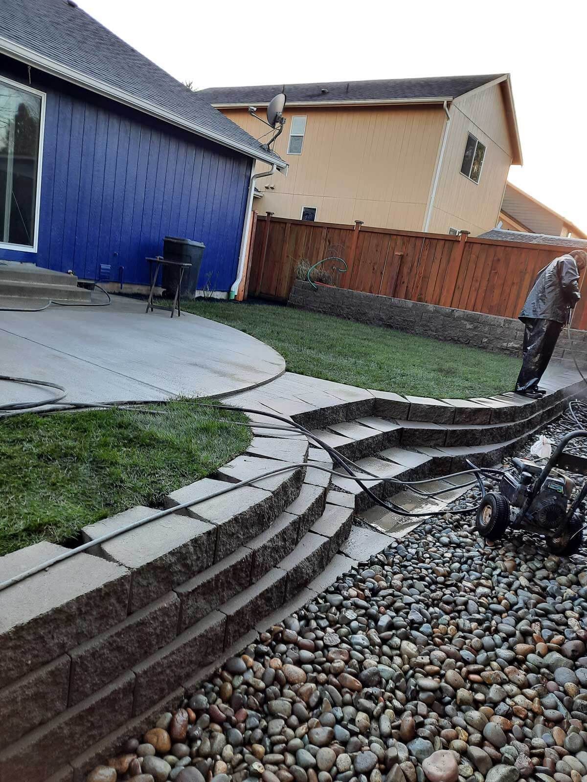 A man is mowing the grass in a backyard.