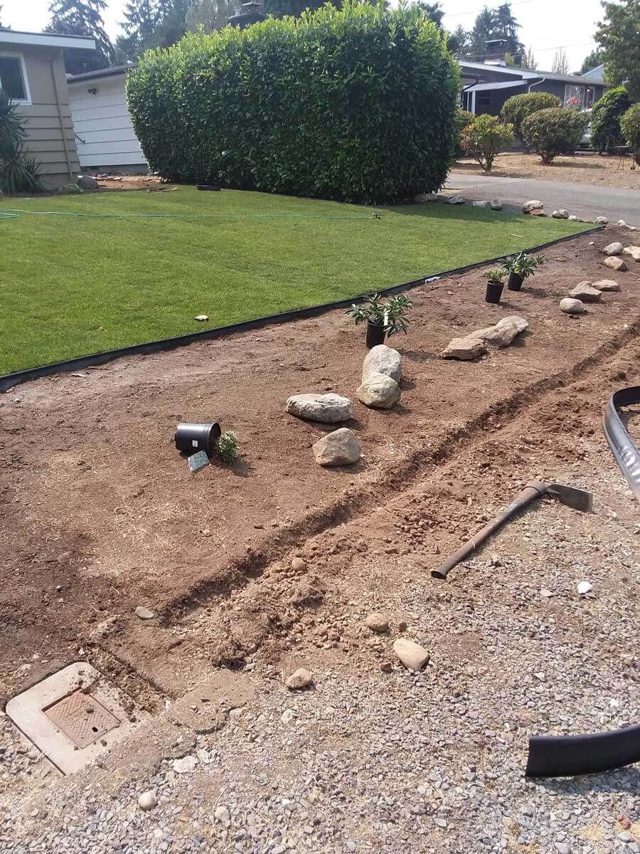 A yard with a lot of rocks and dirt in front of a house.