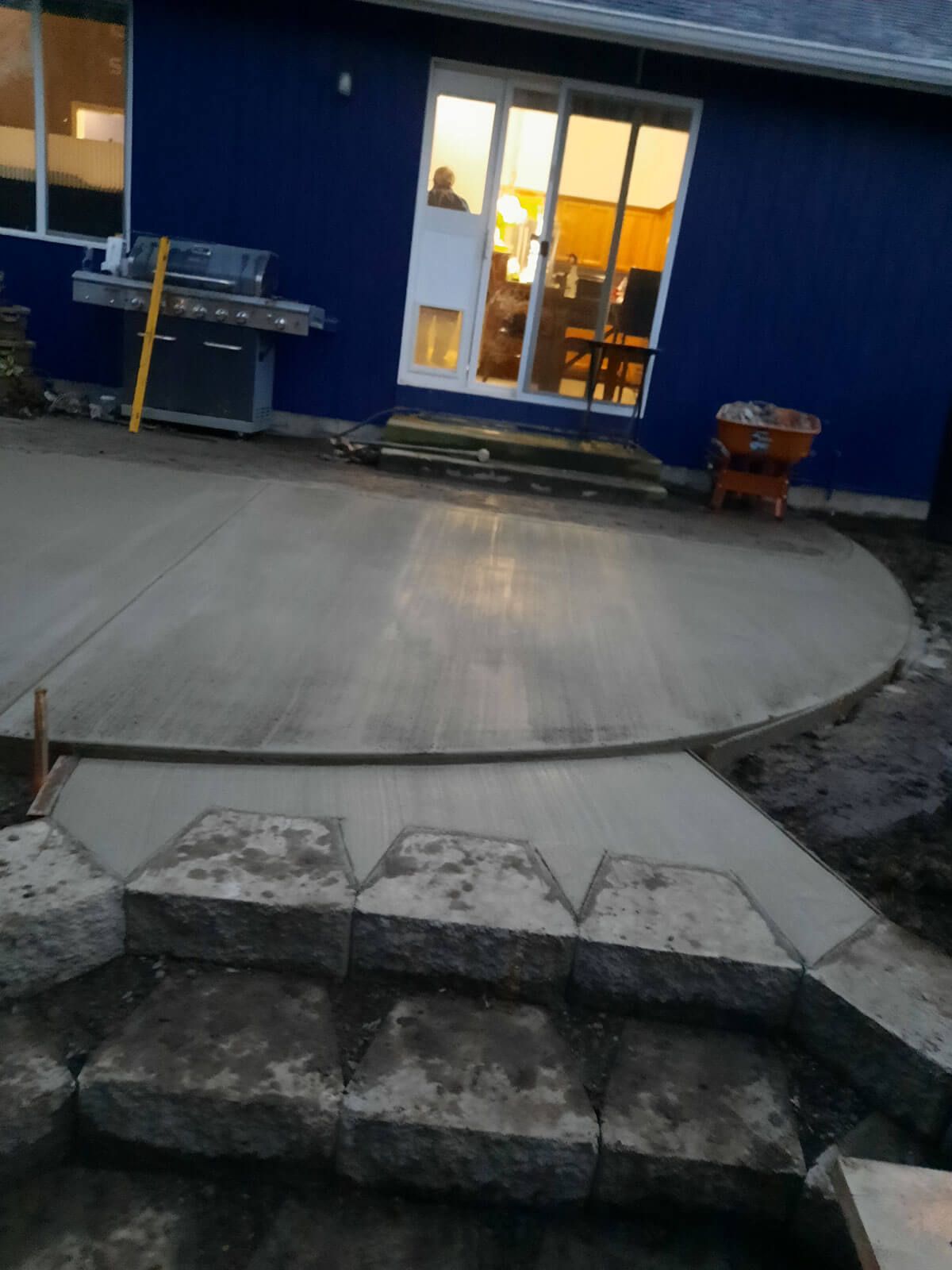 A blue house with a concrete patio in front of it