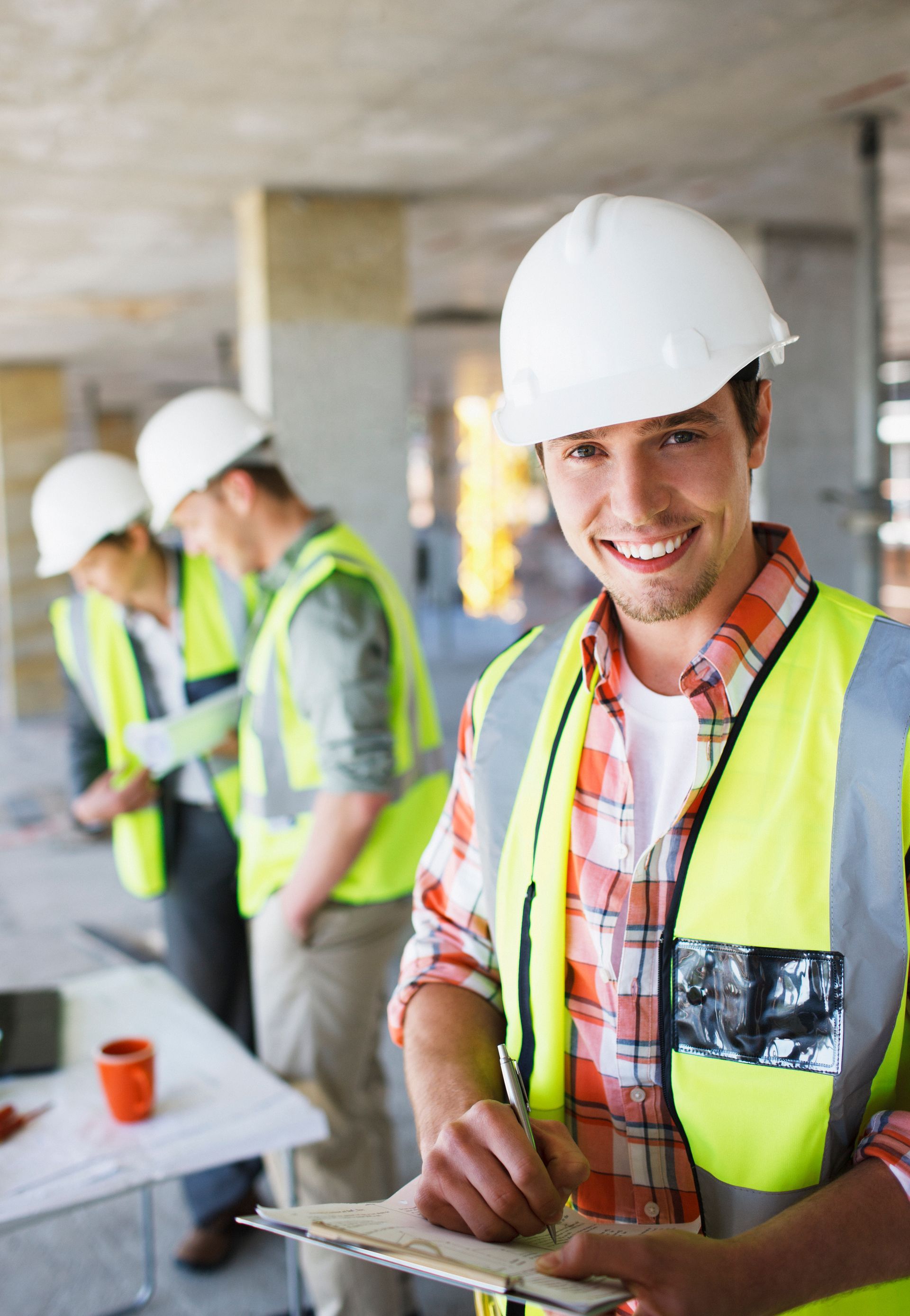 Two women in business attire reviewing a tablet together, seated at a table with coffee cups.