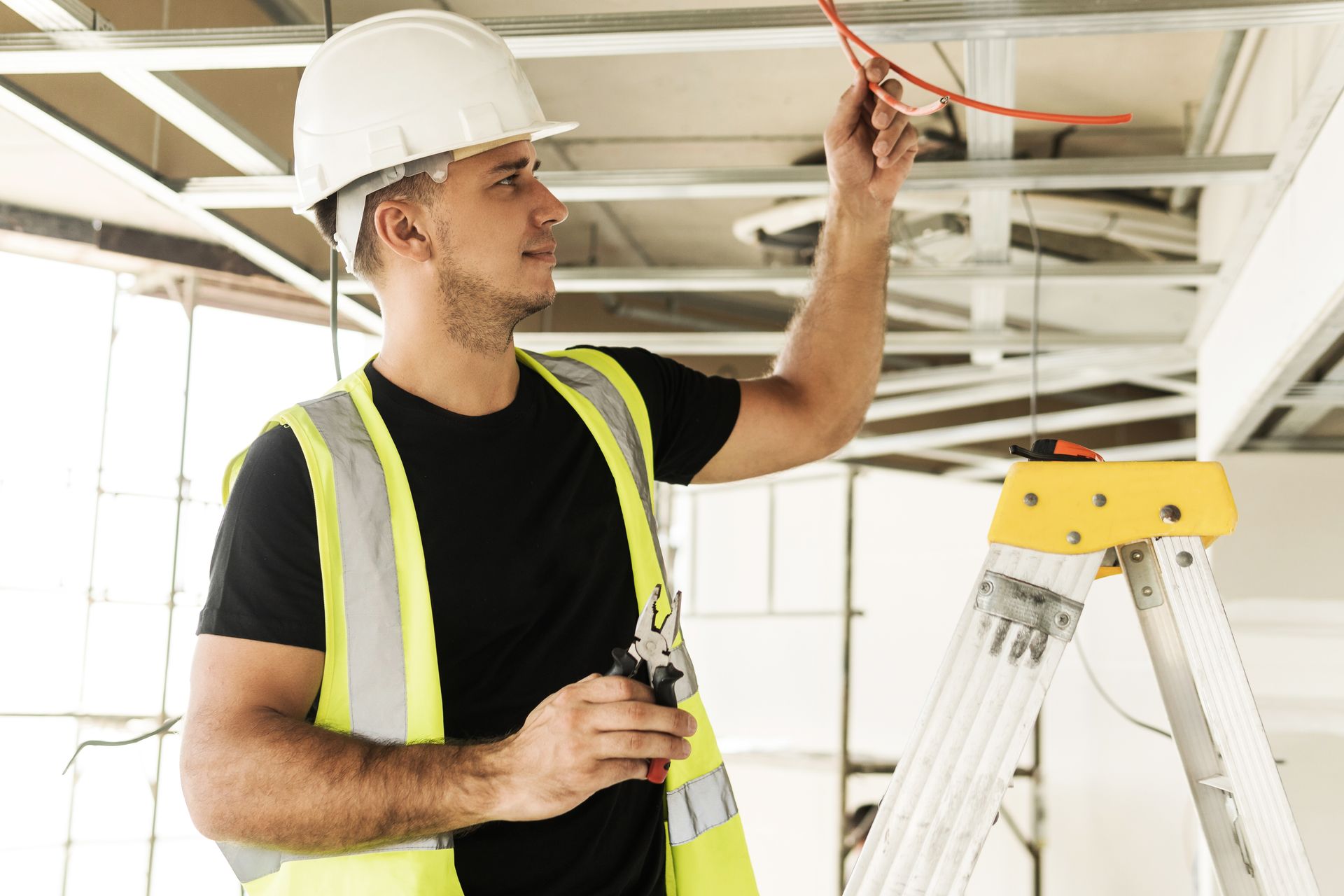 Two construction workers wearing hard hats, reviewing blueprints at a construction site.