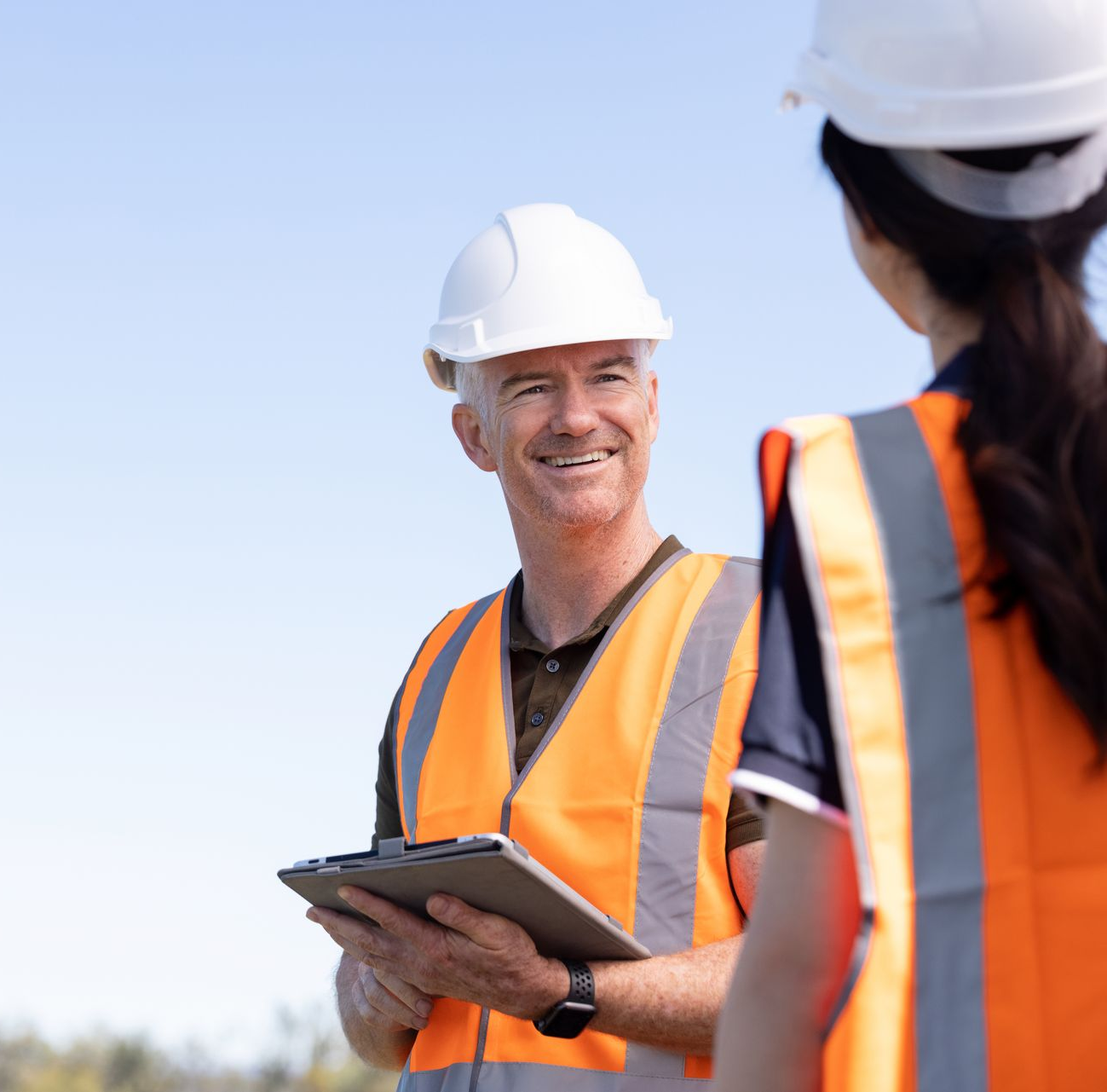 Woman in headset and man looking at a laptop together, possibly in an office.