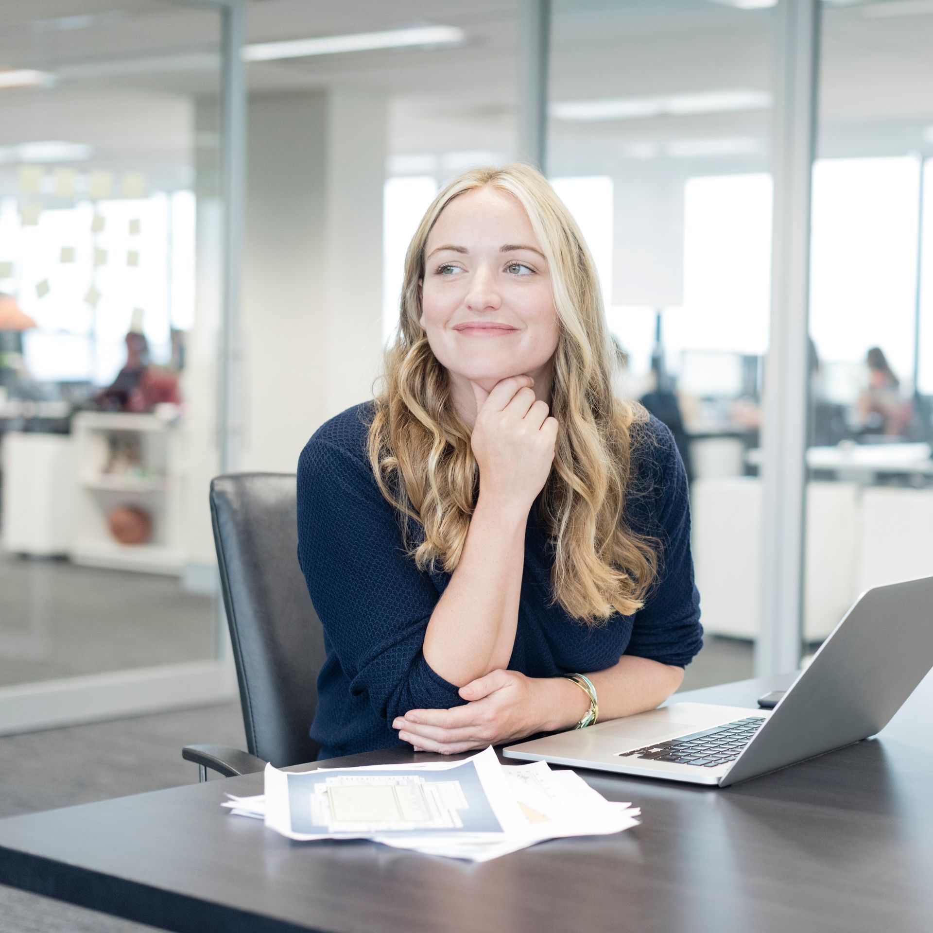 Person using calculator and writing on paper at a desk, with a keyboard and phone.