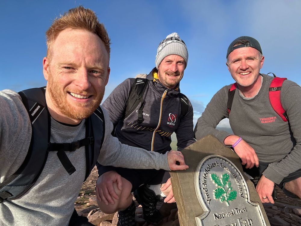 Website Sorted Three Peaks Challenge | Three men are posing for a picture on top of a mountain.
