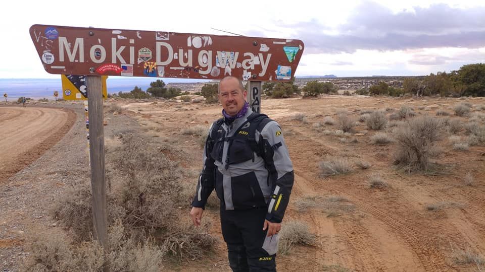 A man is standing in front of a sign that says moki uruguay