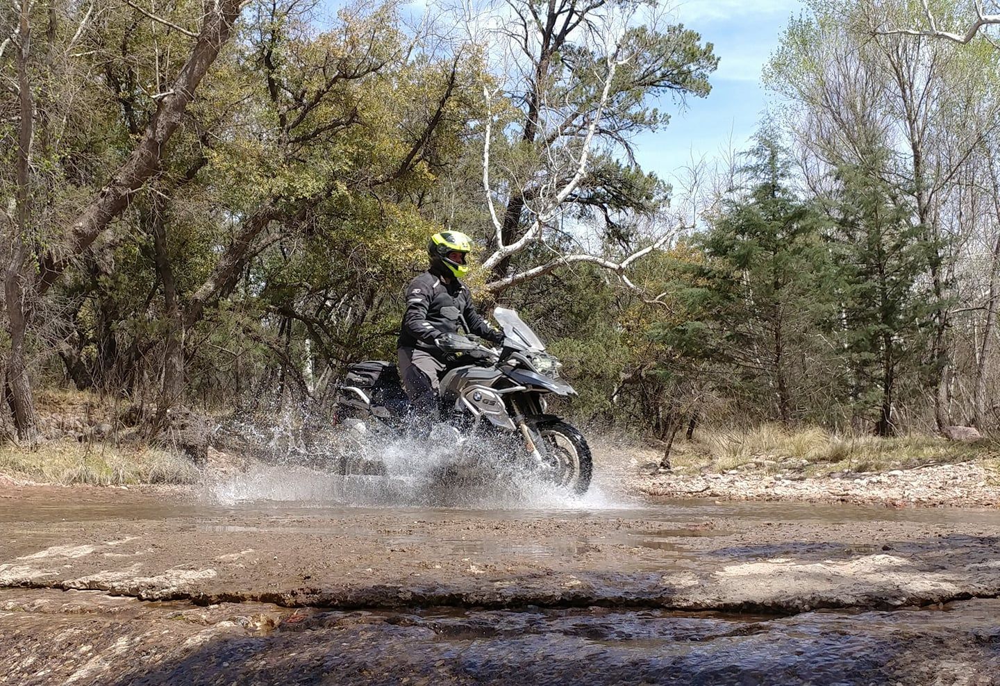 A man is riding a motorcycle through a muddy field.