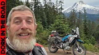 A group of people are riding motorcycles down a dirt road.