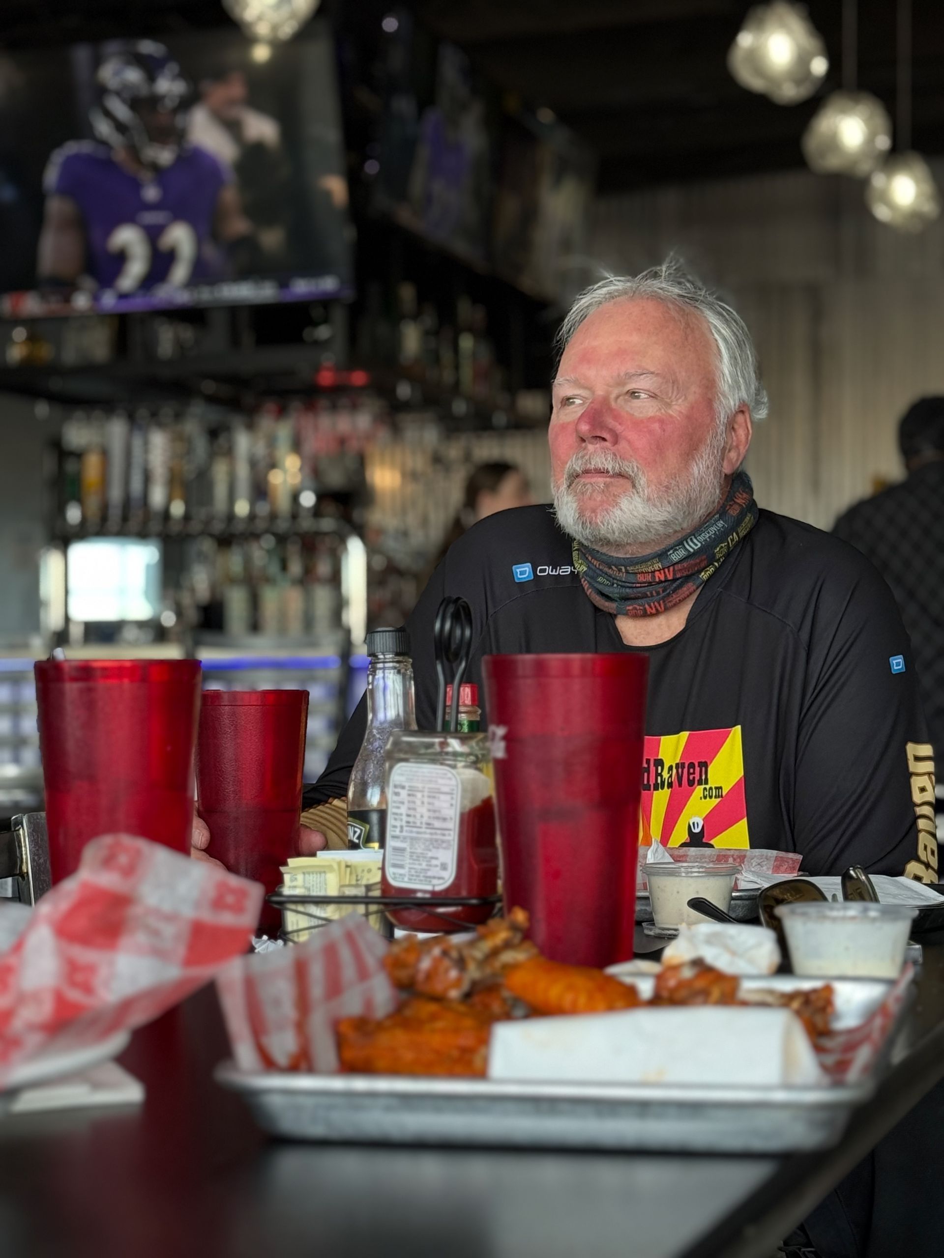 Man sitting at a table in a restaurant with red cups. 