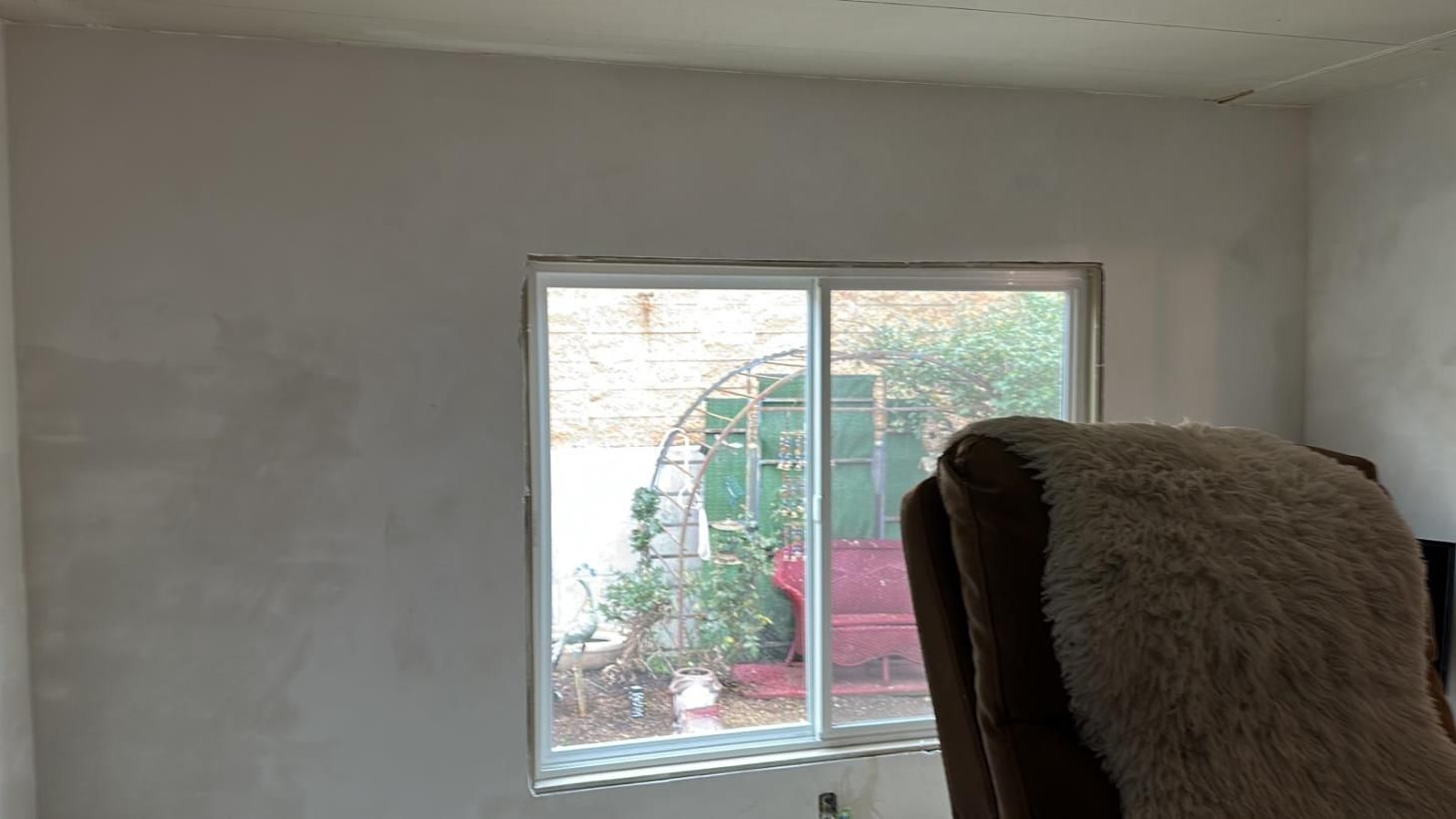 a man wearing a hard hat is plastering a wall