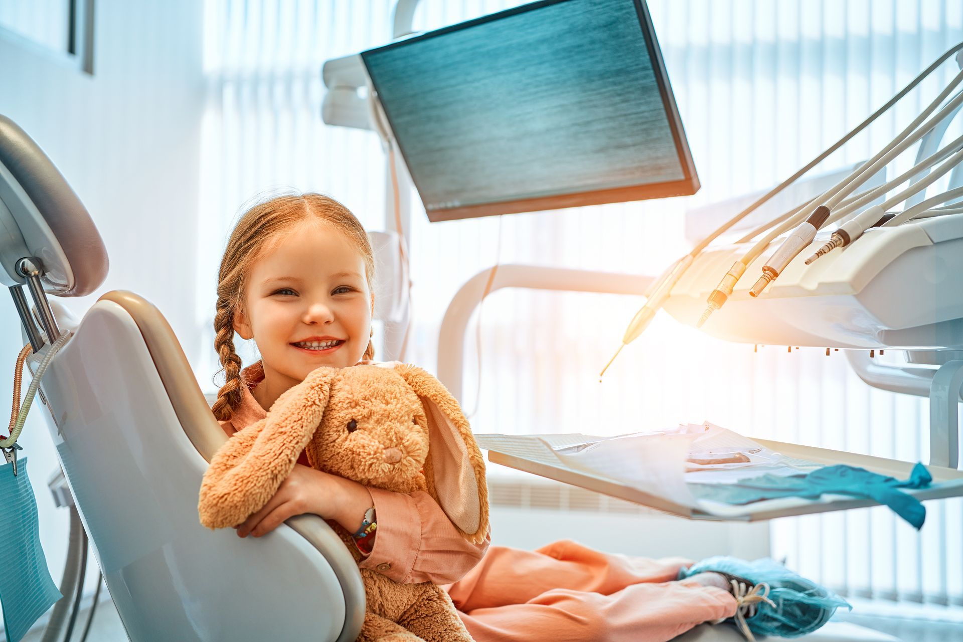 Happy child holding a bunny at a family dentist office, showing a comfortable dental experience.