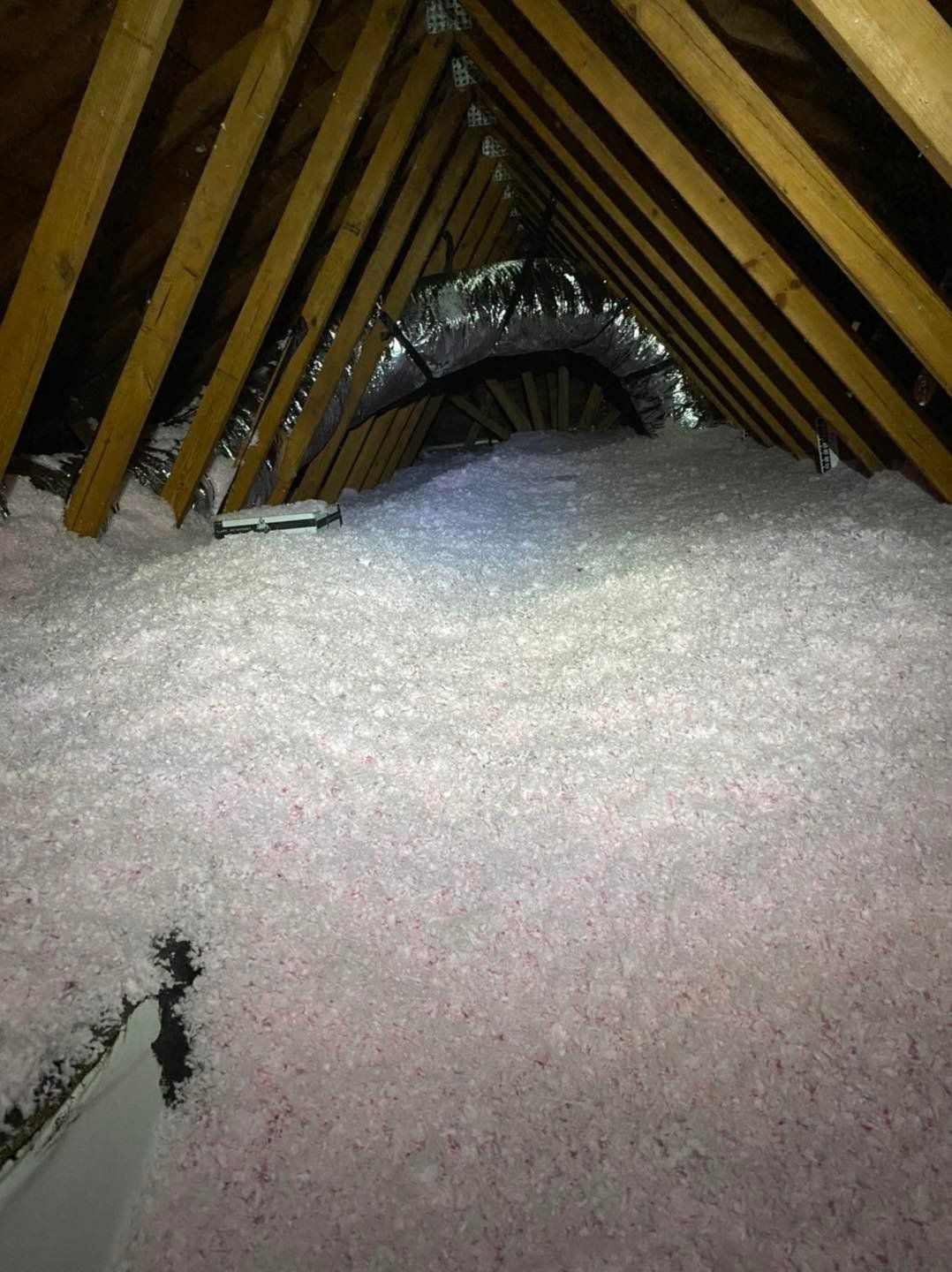 There is a lot of insulation in the attic of a house.