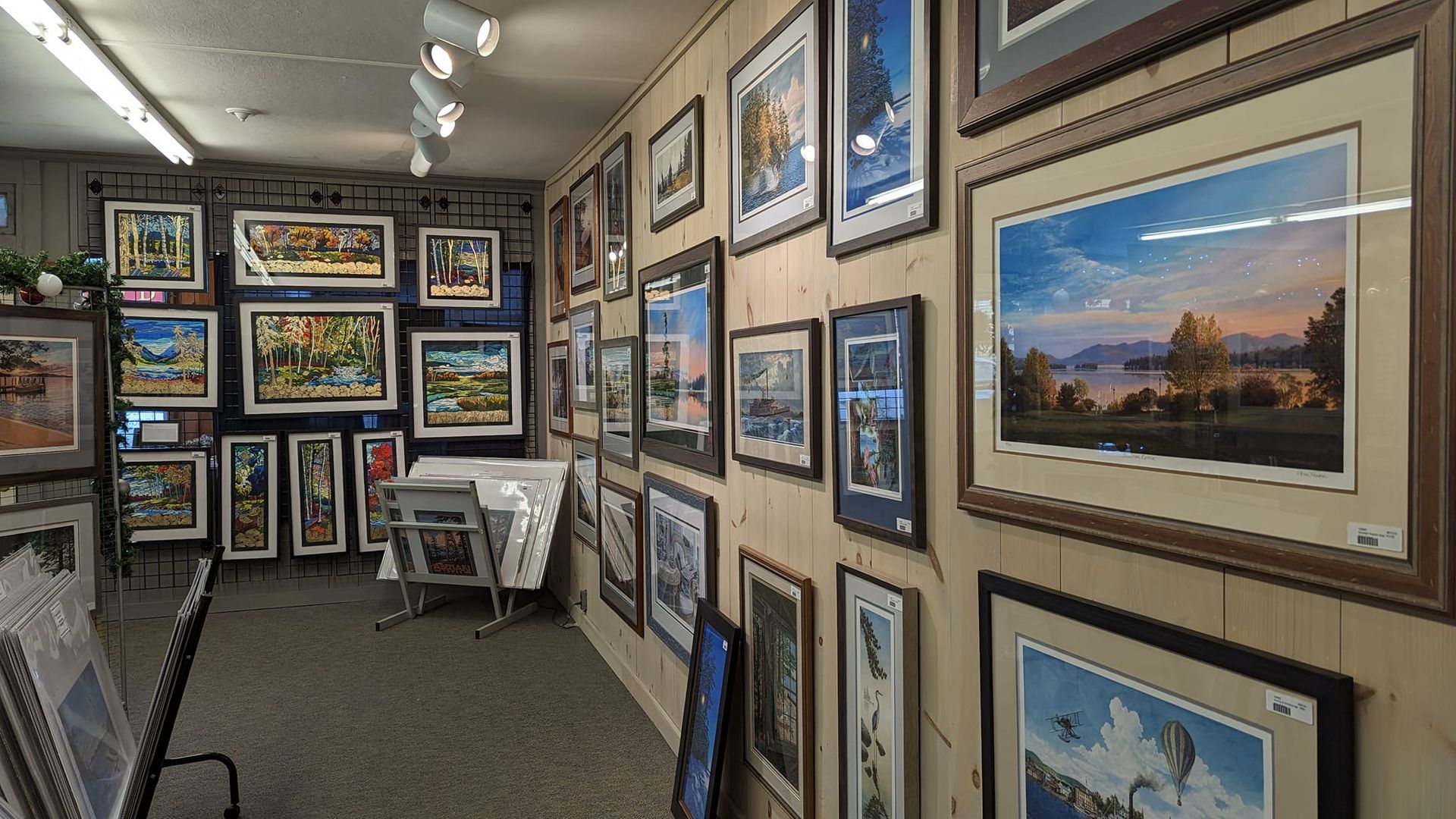 Four framed fish paintings: rainbow, brook, and lake trout, with brown wooden frames.