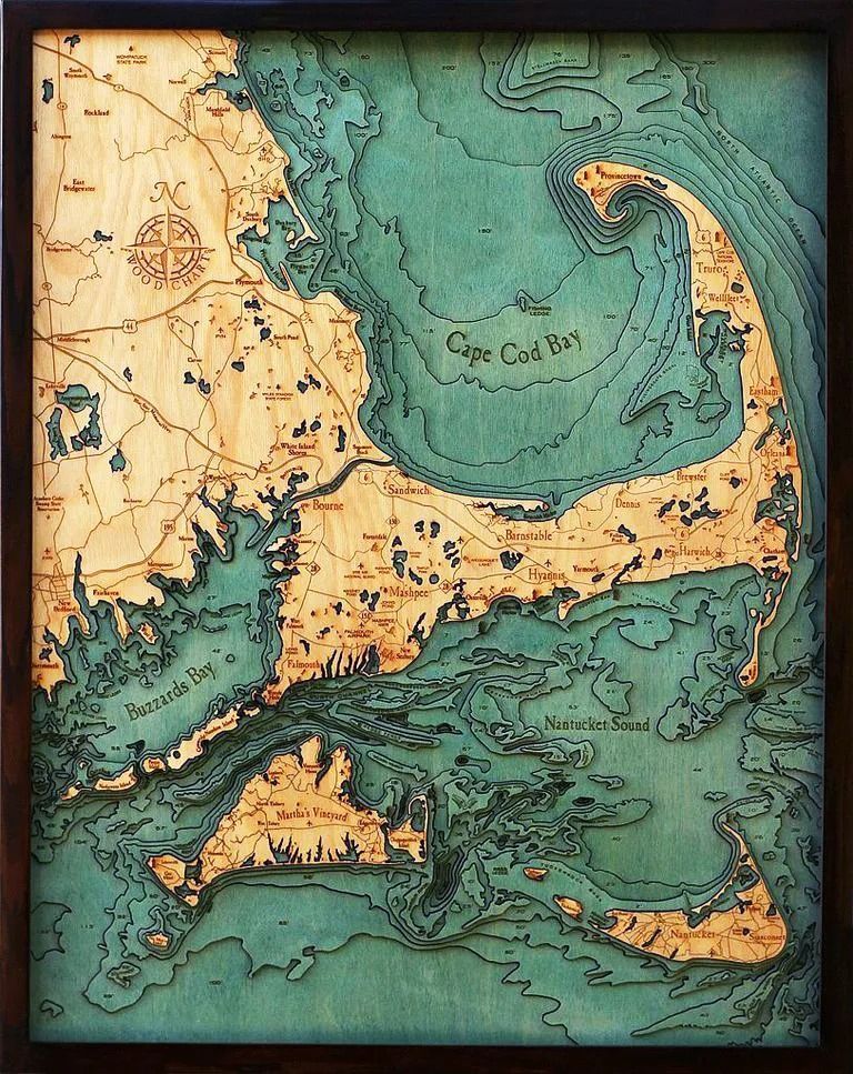 Wooden map of Cape Cod, Massachusetts, with layered topography and blue-green water; framed.