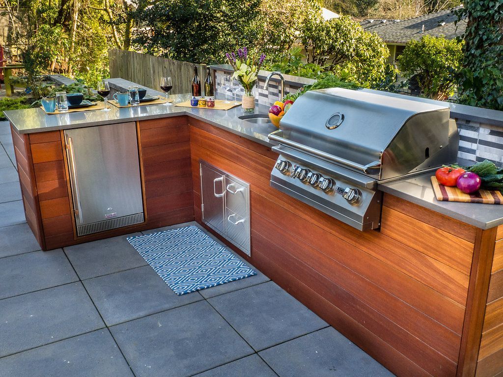 An outdoor kitchen with a grill and a sink