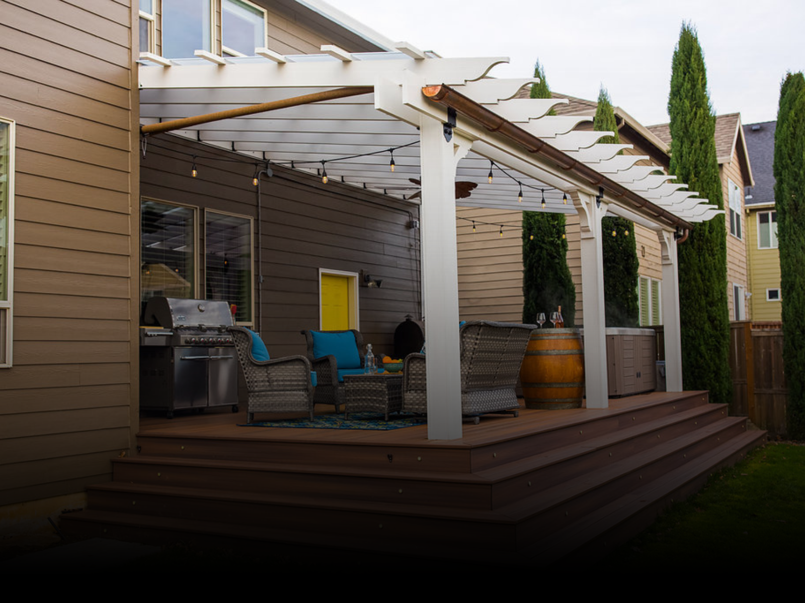 A white Pergola over a TREX deck in the backyard of a house in Southern Oregon