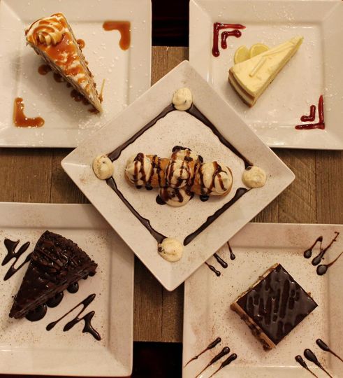 A variety of desserts are on plates on a table