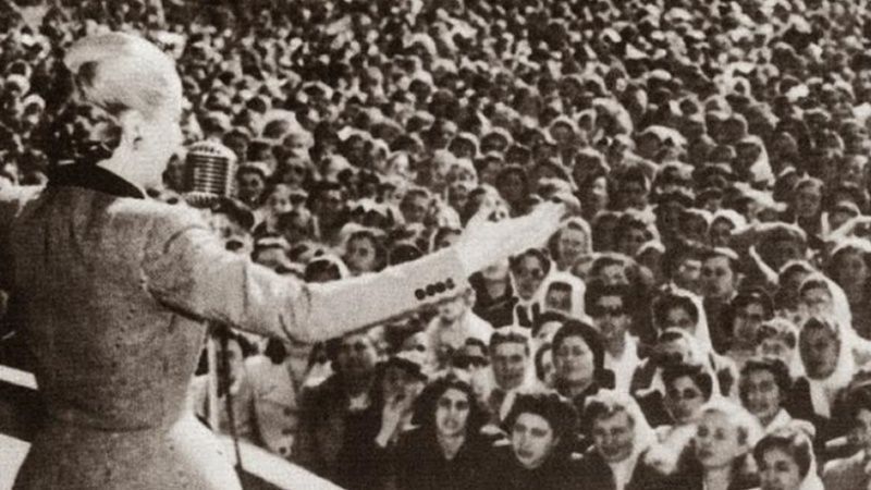 Evita peron with open arms giving a speech to the masses