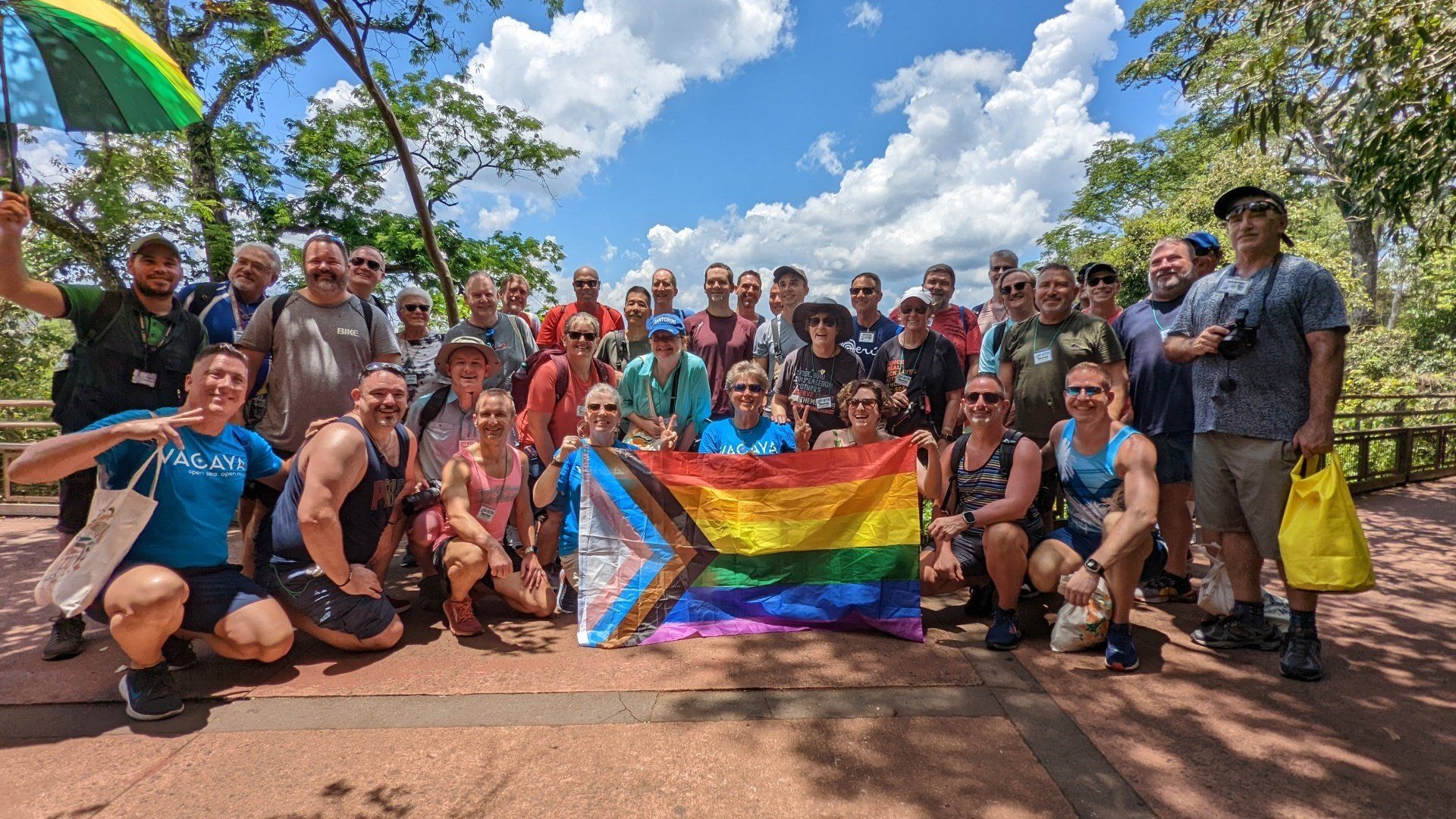 a big group of guests holds the intersectionality flag in the iguazu national park