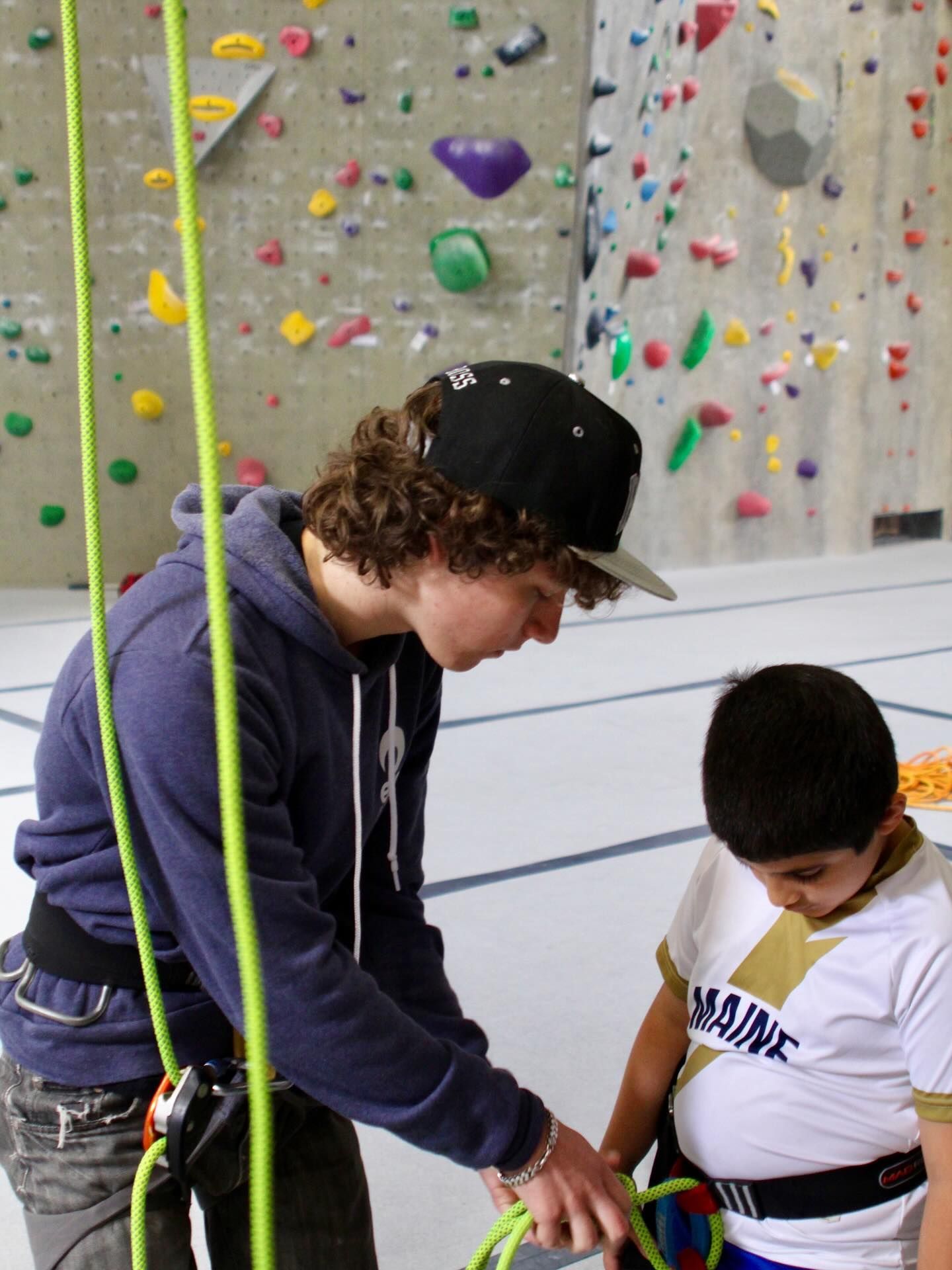Person helps with climbing harness