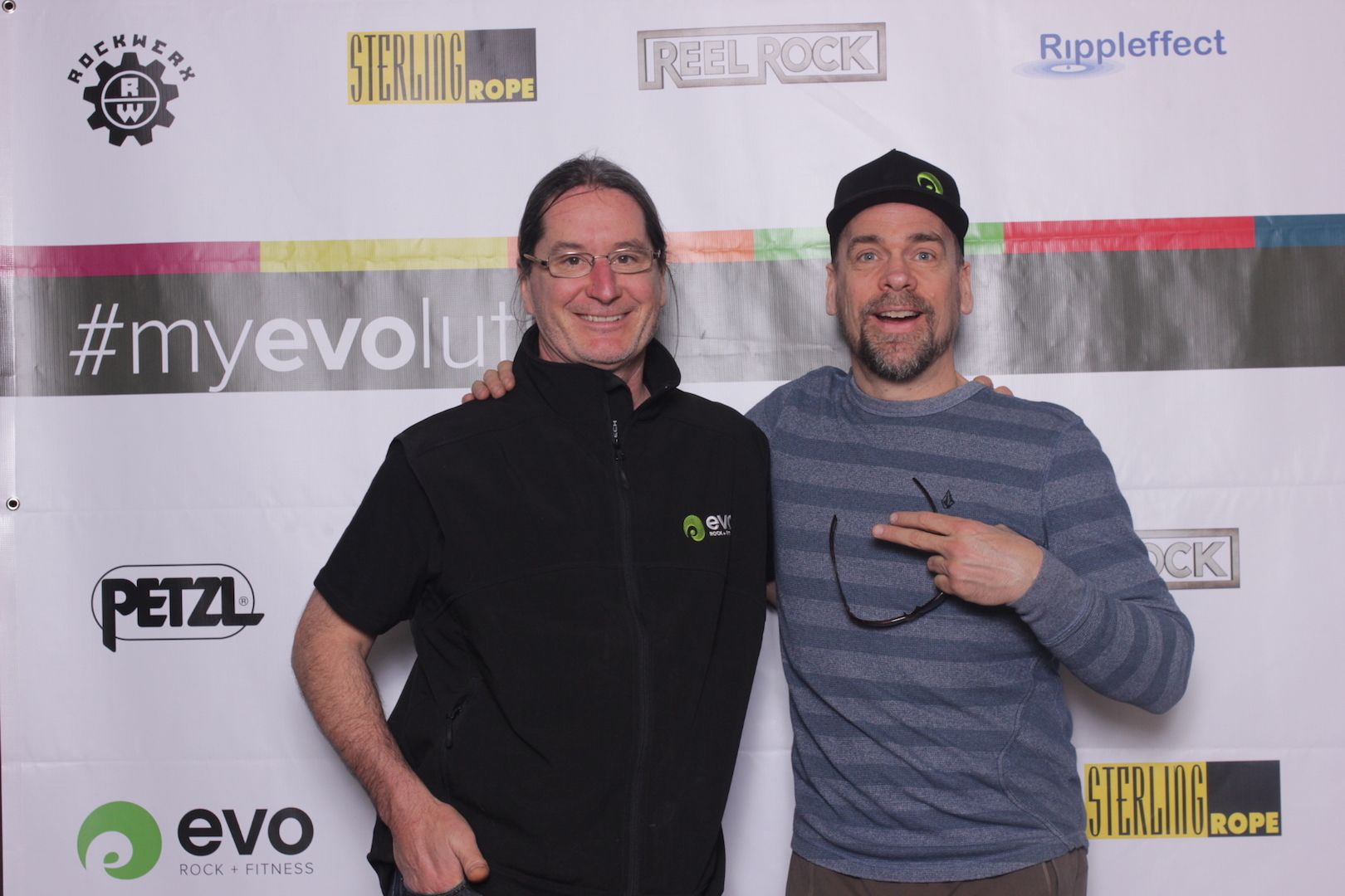 posing in front of a branded backdrop 1