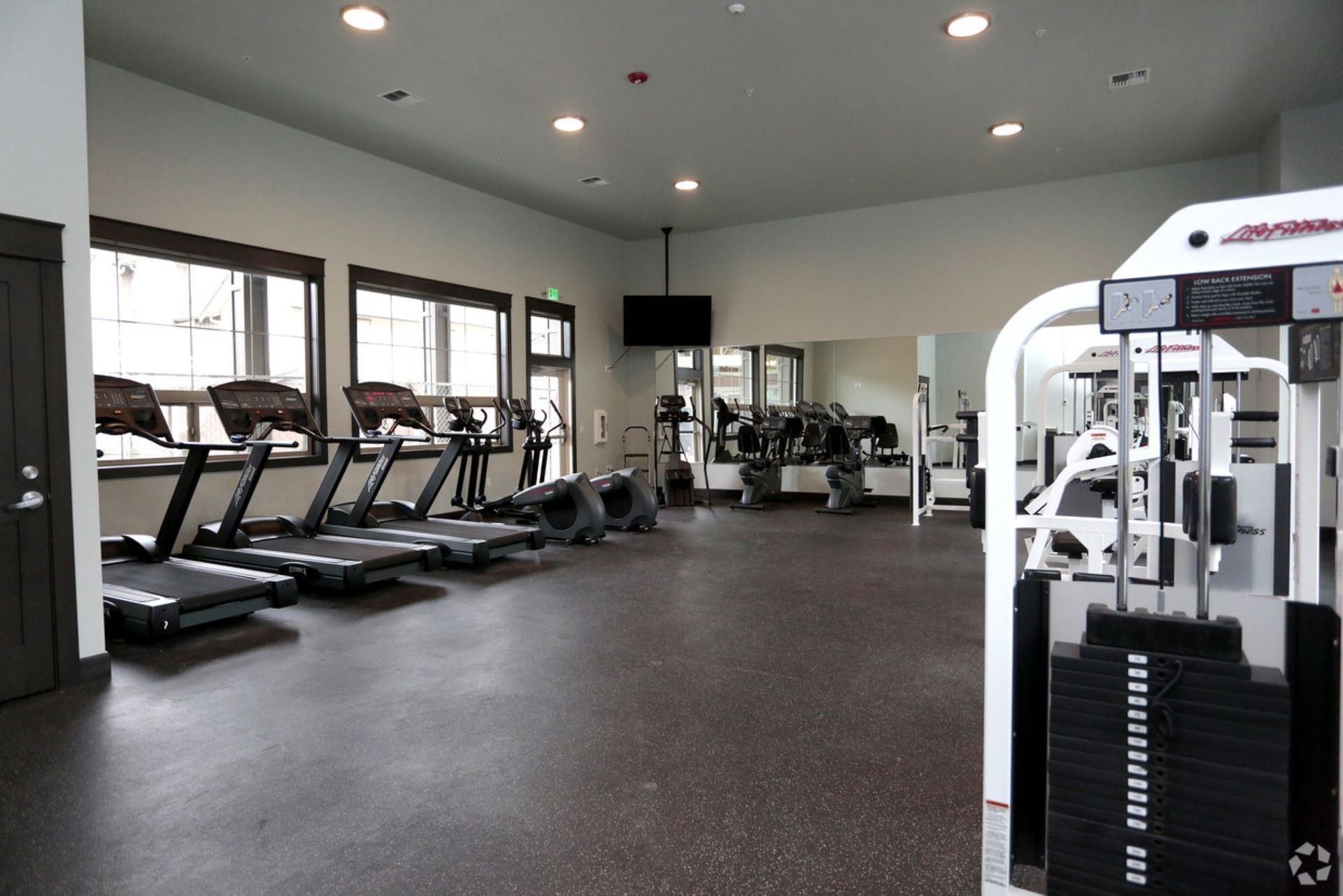 A large gym with a lot of treadmills and exercise machines.