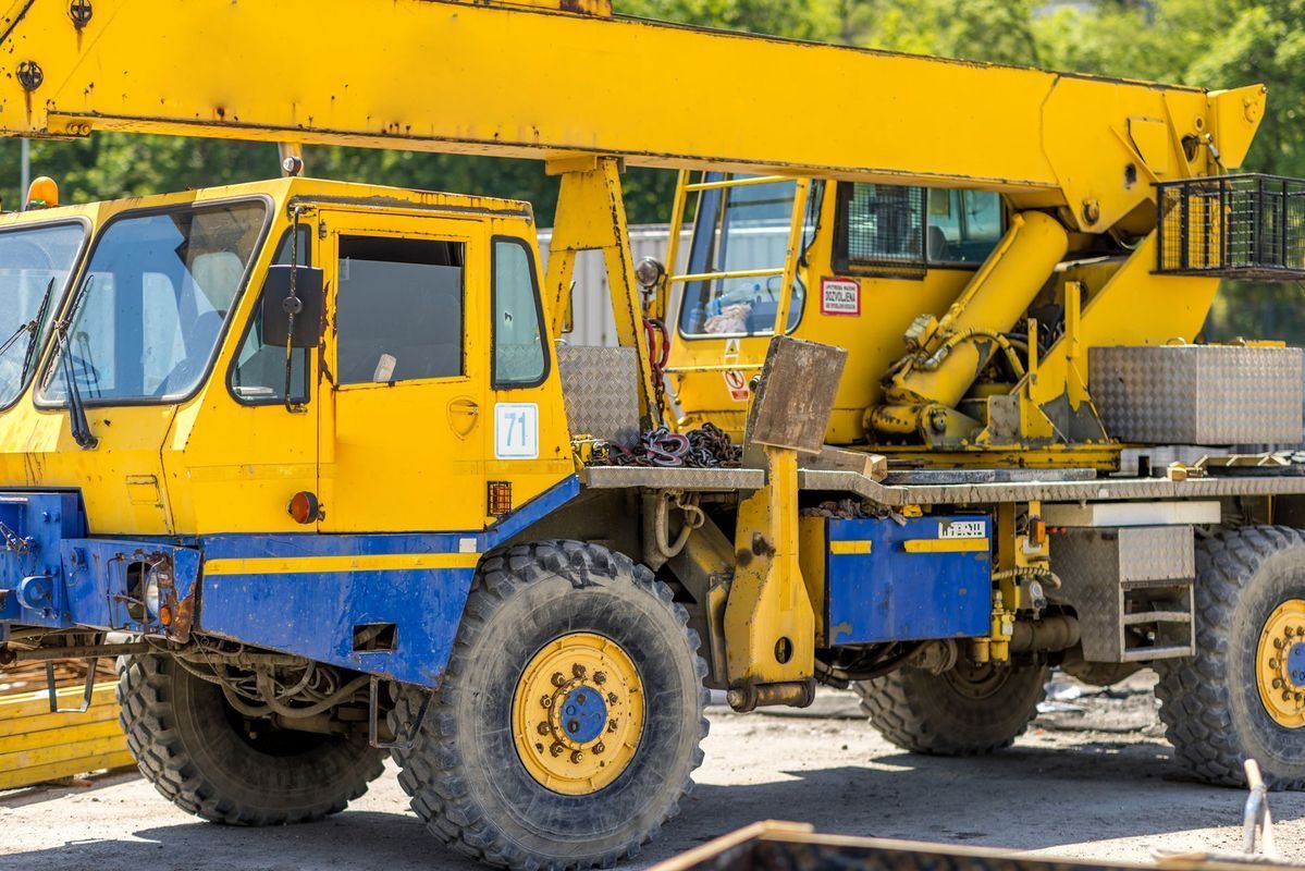 Yellow and blue crane truck on a construction site.